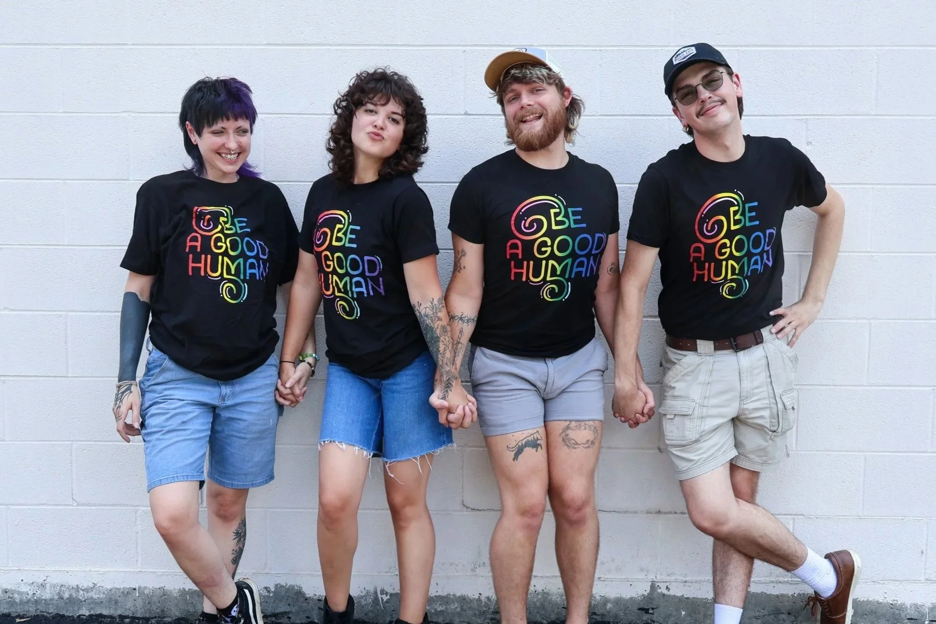 Music City Creative employees standing in front of the print shop wearing t-shirts that say "Be A Good Human."