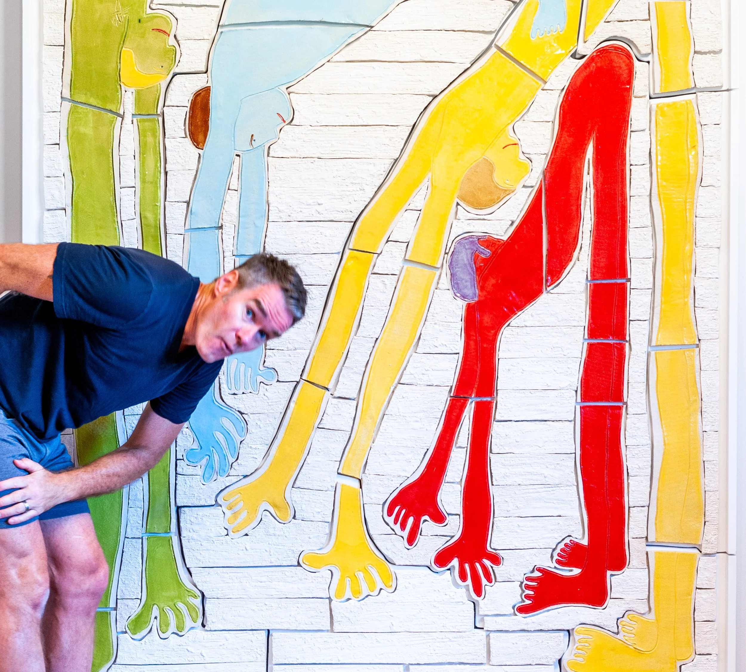Jim Schatz in front of Hold It All Together, ceramic tile mural by J Schatz Studio