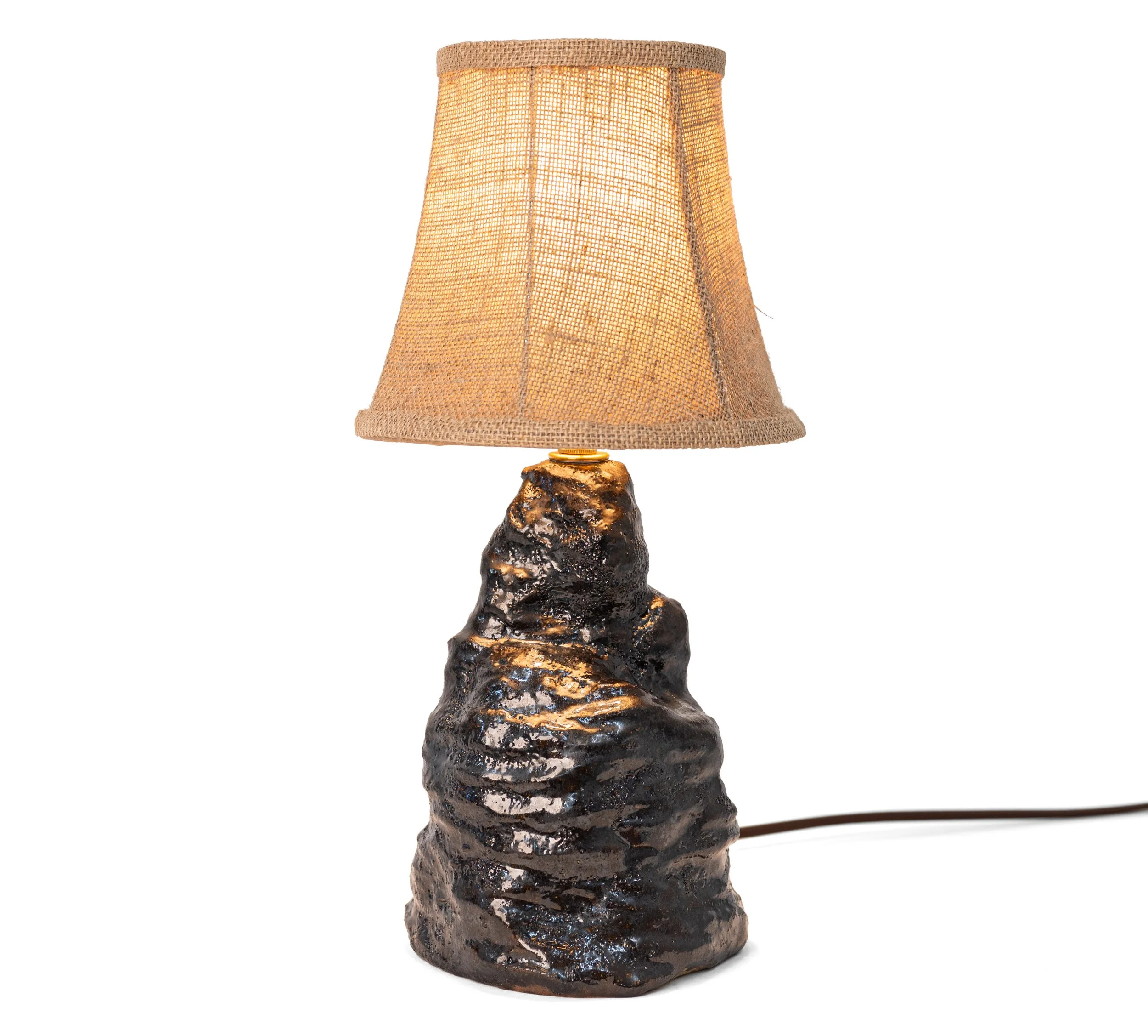 Amorphous Black Metallic Lava Lamps, Lamp 1, a broad craggy stoneware base in black metallic lava glaze under a woven bell shade, by Jim Schatz.