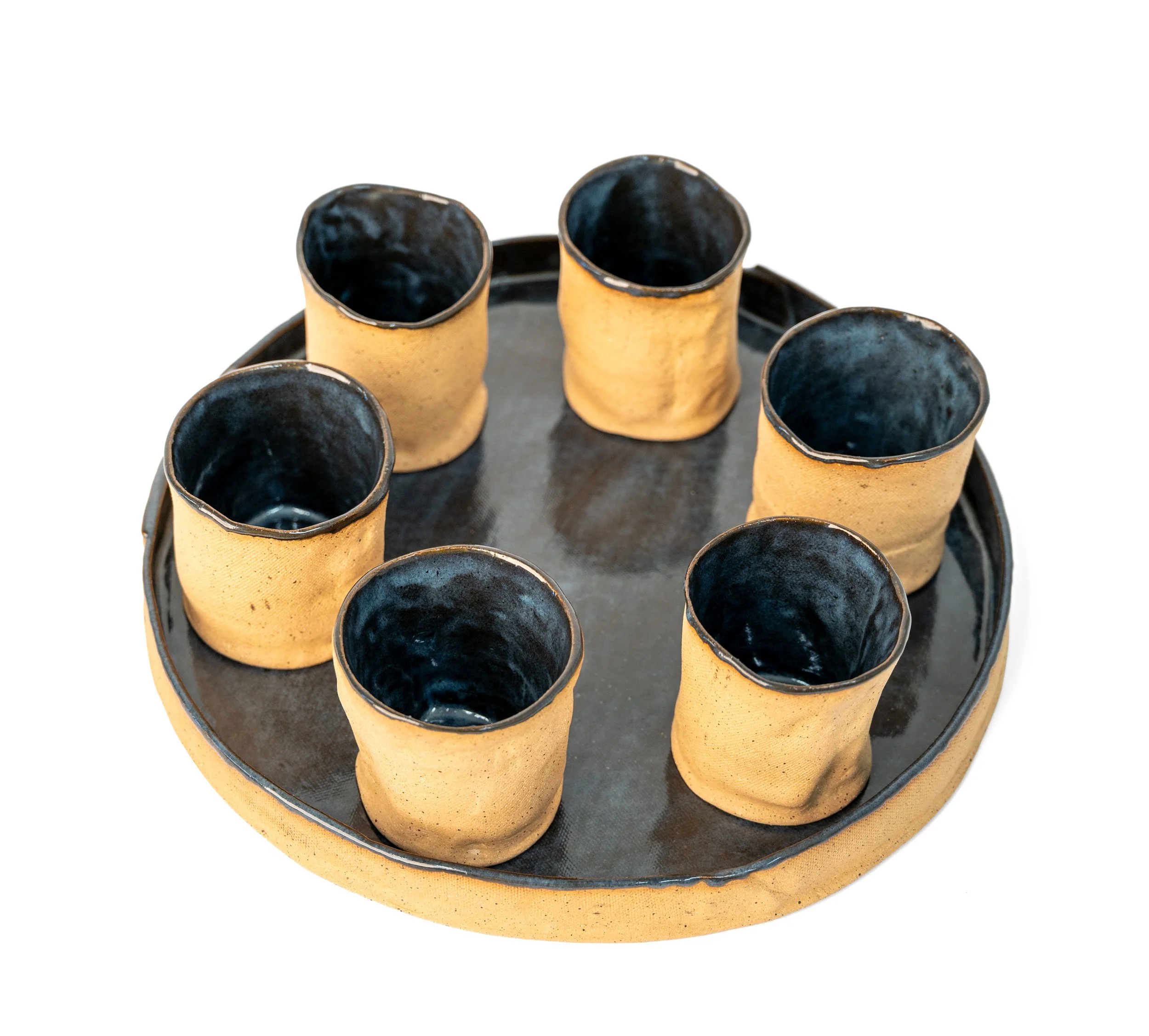 Round Tray and 6 Cups by Peter Souza Jr. — top-down view showing deep blue-black glazed cup interiors arranged in a circle on the glazed tray