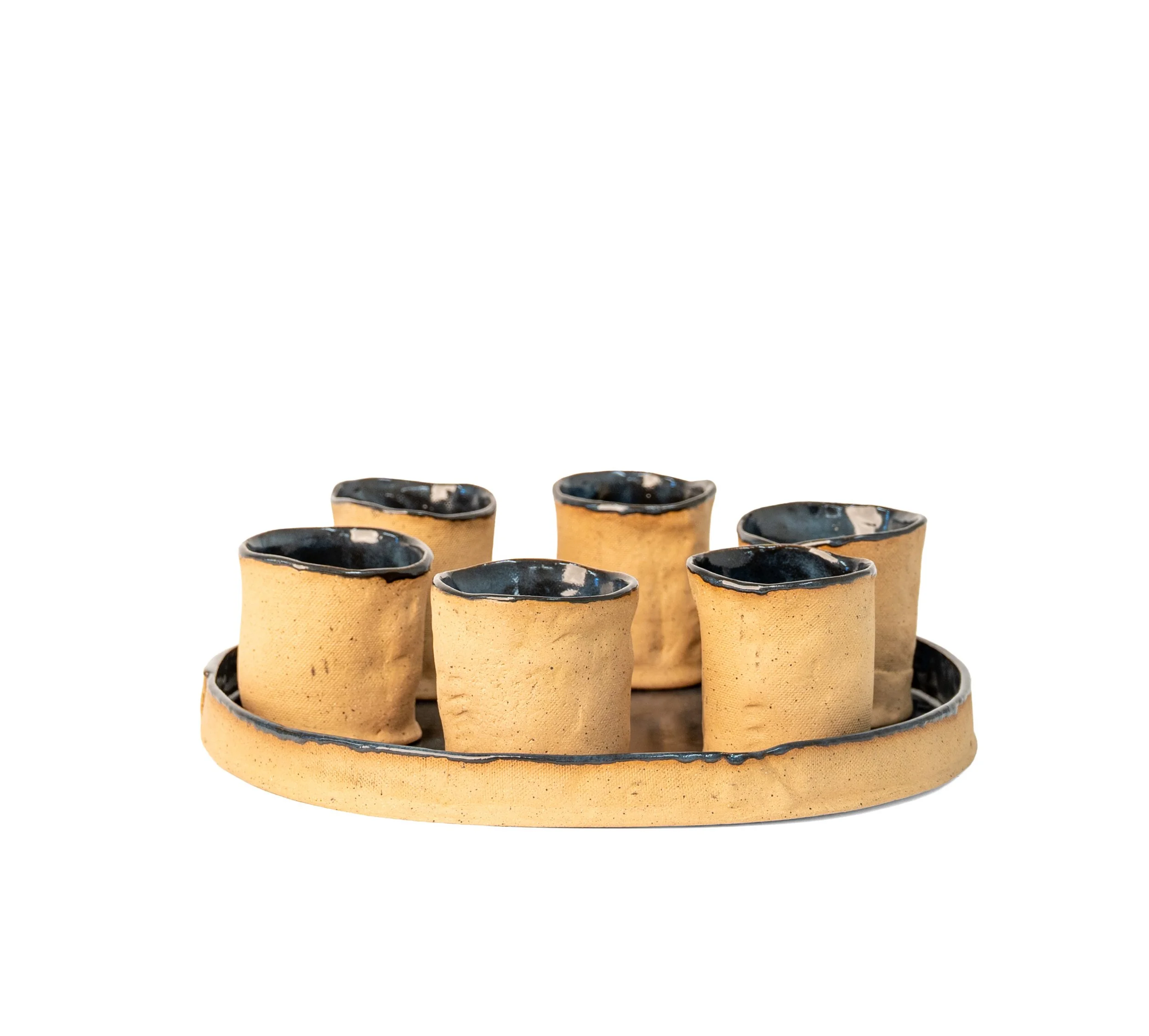 Round Tray and 6 Cups by Peter Souza Jr. — hand-built stoneware serving set with six raw clay cups on a round tray, blue-black glazed rims and tray surface