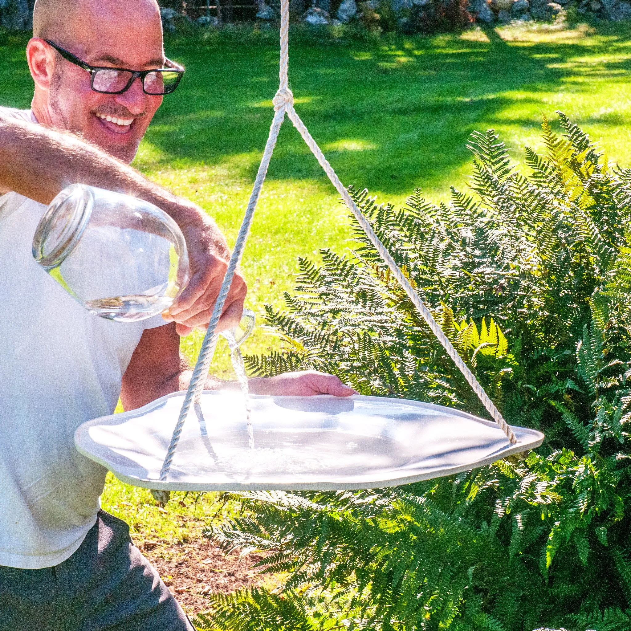 Bird Bath by Jim Schatz — Peter filling the basin with water in a garden