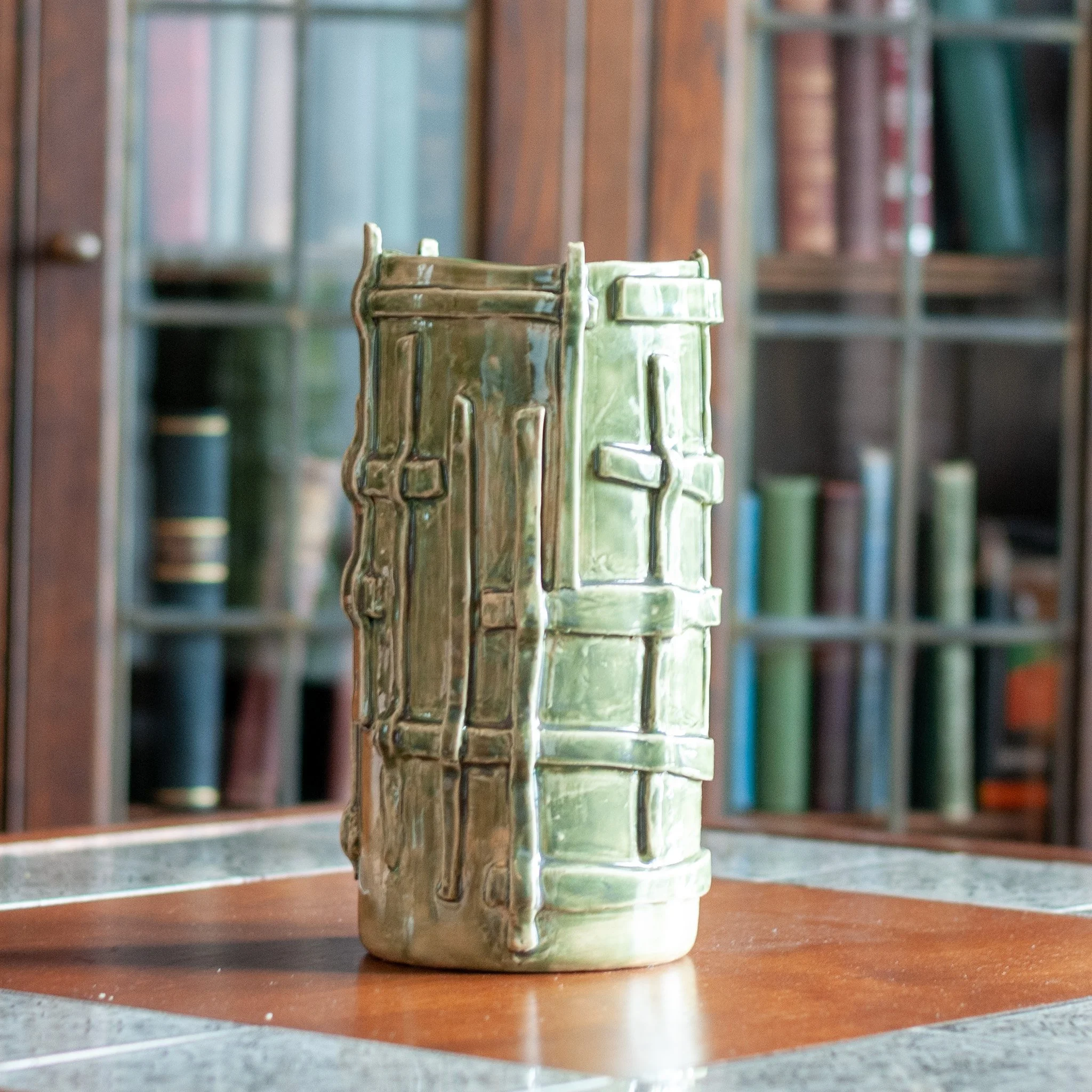 Vessel 1, green-glazed stoneware vessel styled on a wood table