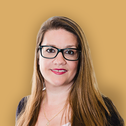 A portrait of a woman with long light brown hair wearing glasses, a black blazer, and a white top against a blurred beige background.
