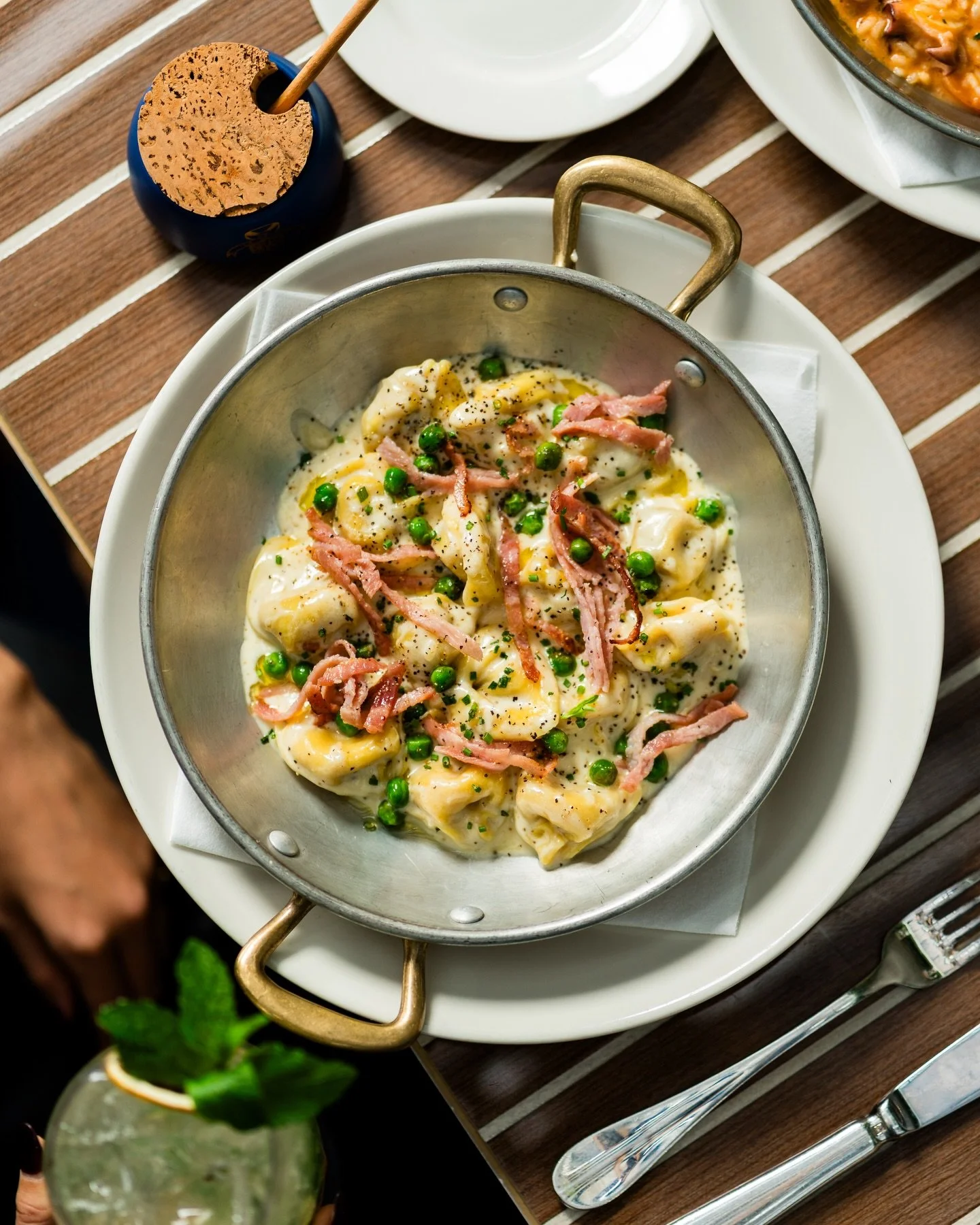 Delicate pasta stuffed with mortadella and beef, bathed in a velvety cream sauce with peas and prosciutto. A rich, soulful twist on a timeless classic.