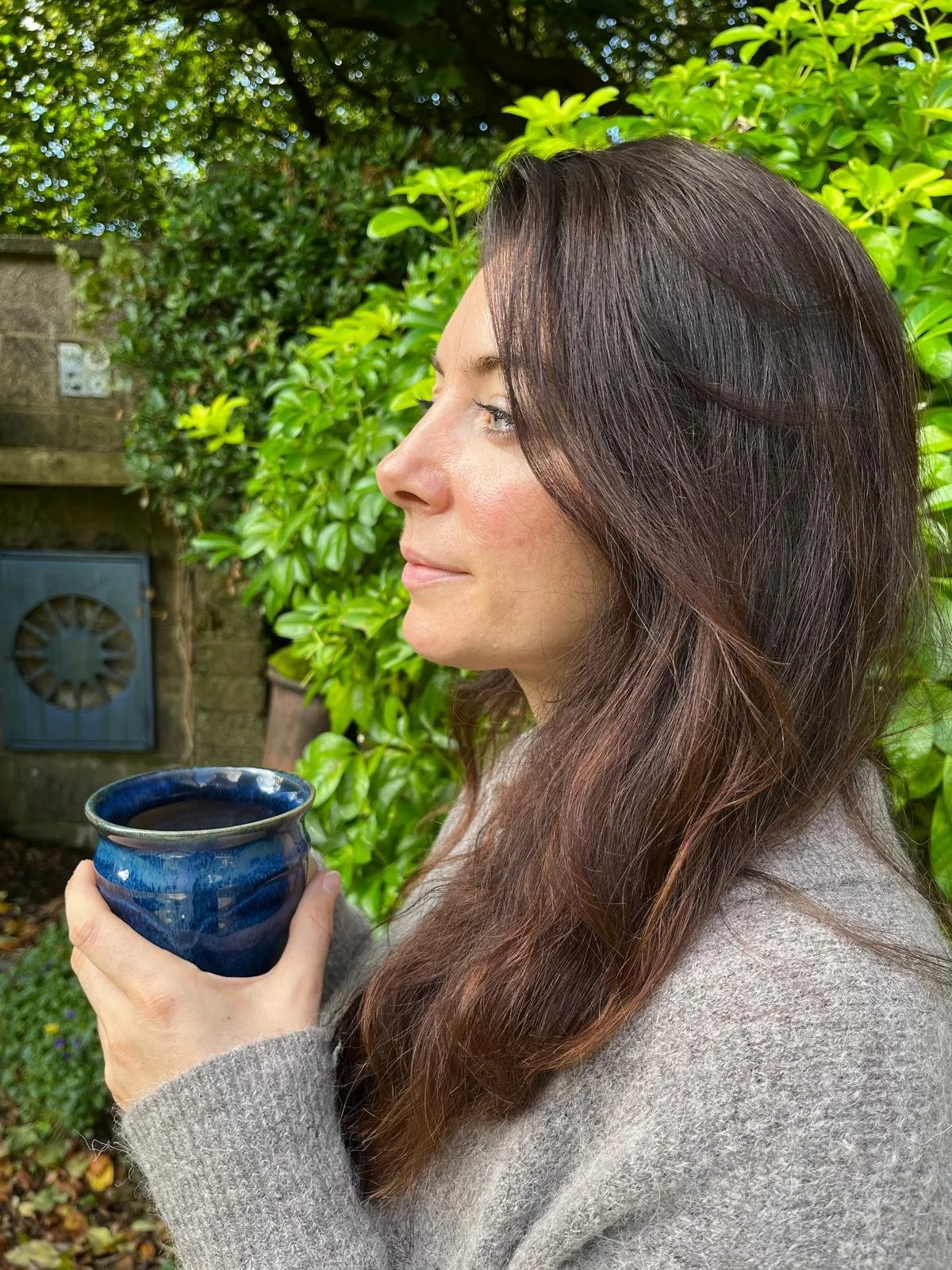 Alana Feehely, co-founder of Andala Wellness, outdoors with a cup of tea.