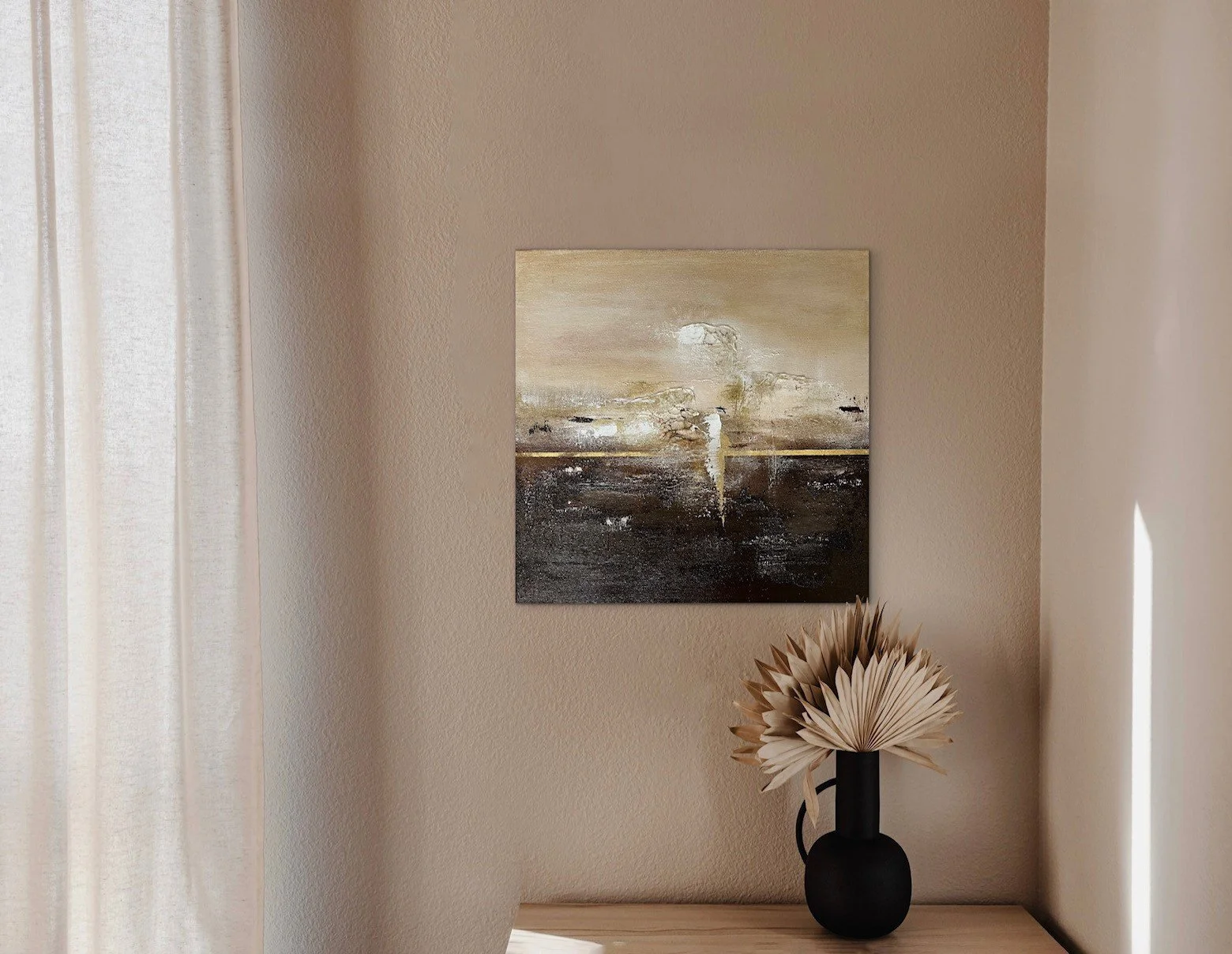 Ein abstraktes Gemälde an einer hellen Wand, darunter eine schwarze Vase mit getrockneten Pflanzen auf einem Holztisch.