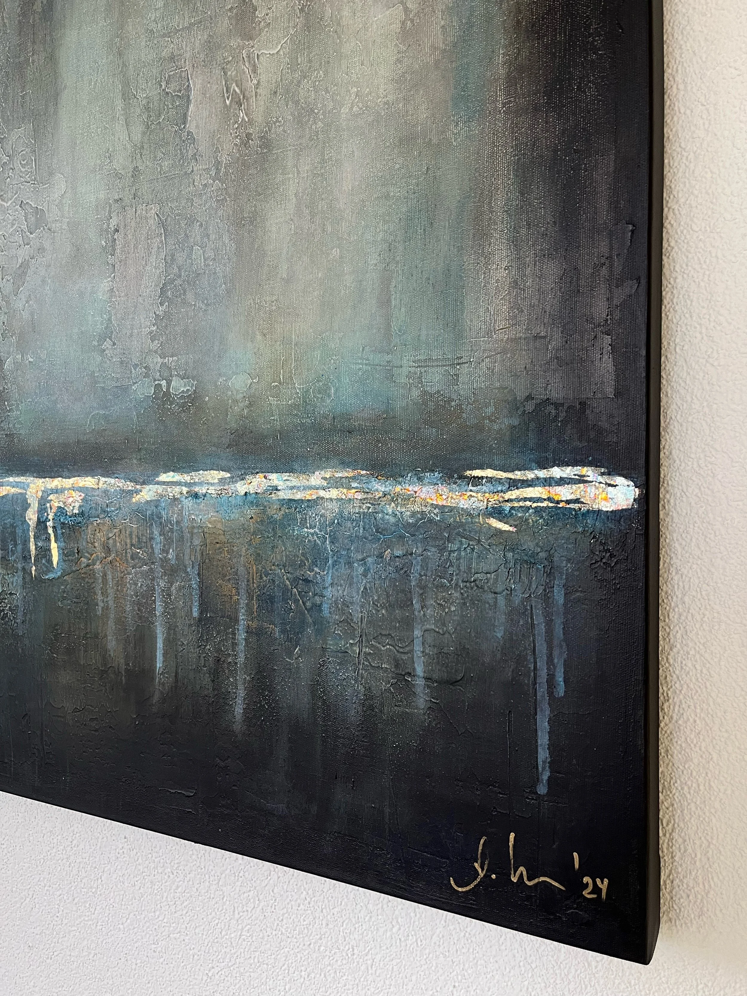 Abstraktes Gemälde mit dunklen Farben, texturierte Oberfläche, goldene Akzente, Signatur 'J. Sch.' und das Jahr '24' im unteren rechten Eck.