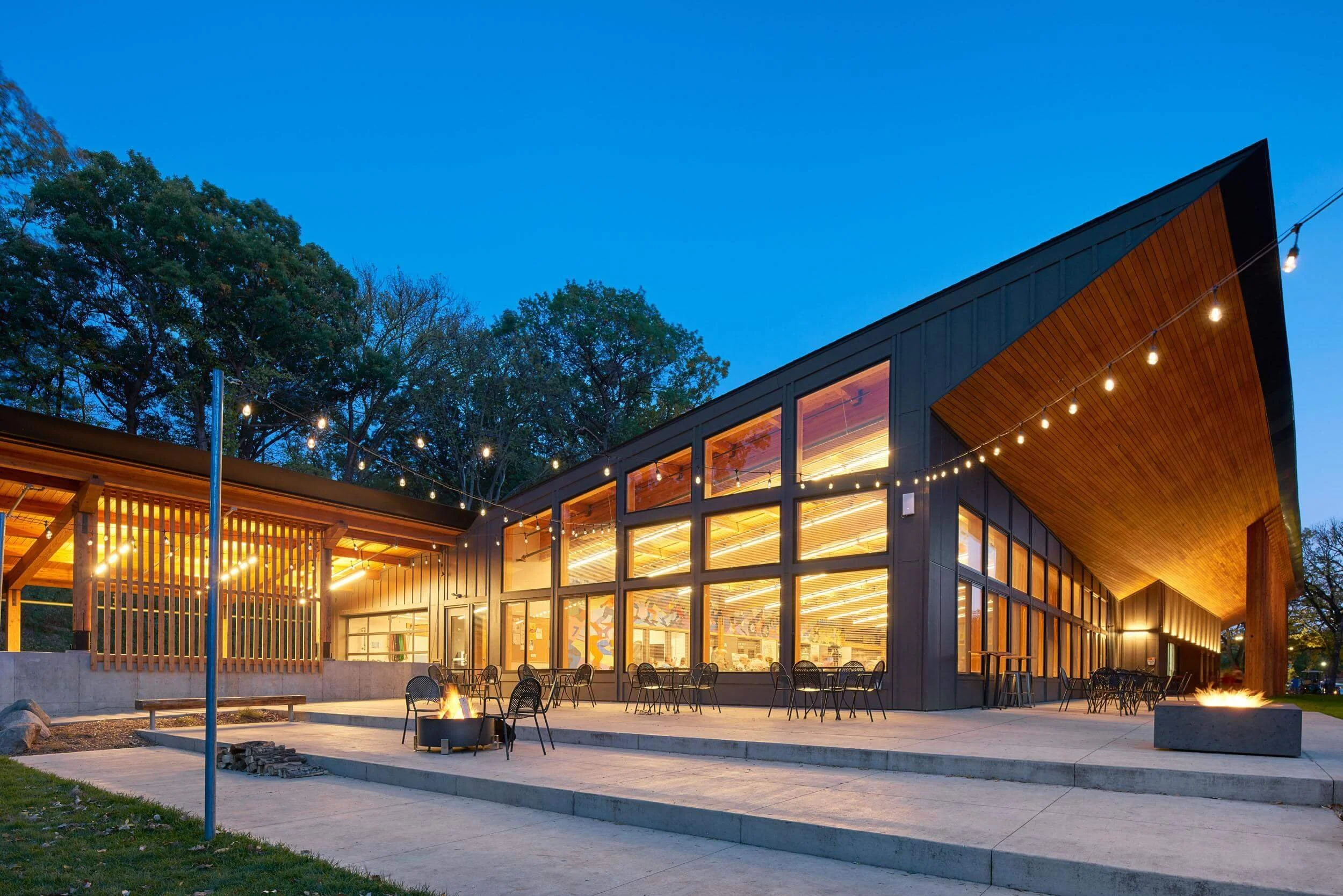 Exterior view of the Trailhead building at Theodore Wirth Regional Park, one of the best winter wedding venues in Minnesota, in the evening with twinkle lights in the courtyard