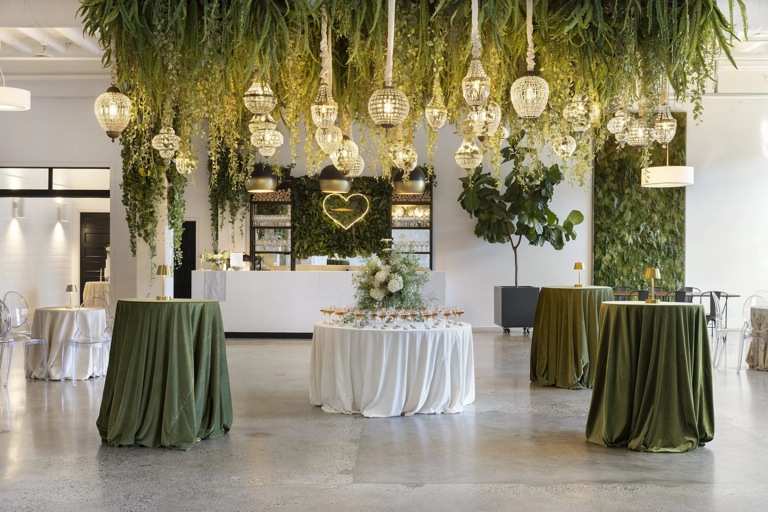 Decorated room filled with greenery and hanging lights at Urban Daisy, one of the best winter wedding venues in Minnesota