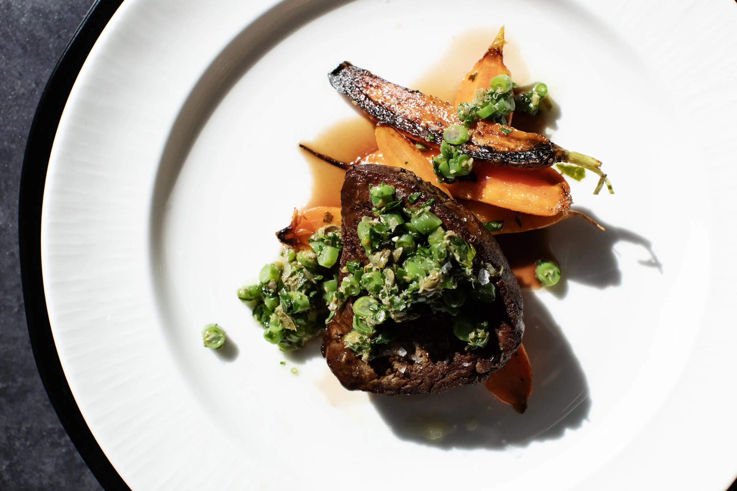 Elegant plated steak entree with roasted carrots