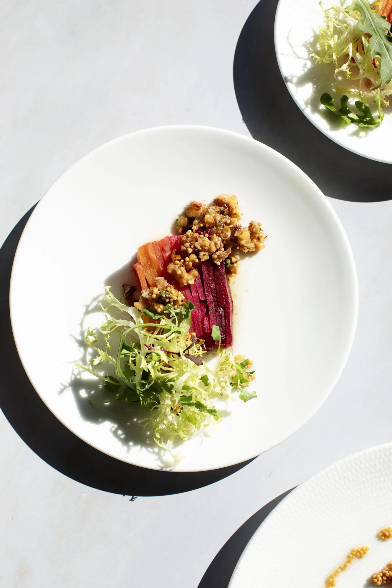 Plated roasted red and gold beet terrine with frisée and candied walnuts — Food Gallery Catering wedding menu Minneapolis