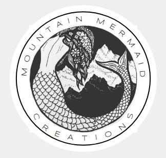A circular logo featuring a mountain landscape and a mermaid with detailed scales and hair, with the text 'Mountain Mermaid Creations' around the border.