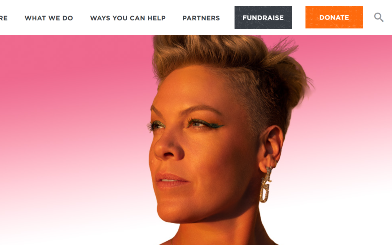 Close-up of a woman with short, styled hair and earrings, looking to the side against a pink gradient background.