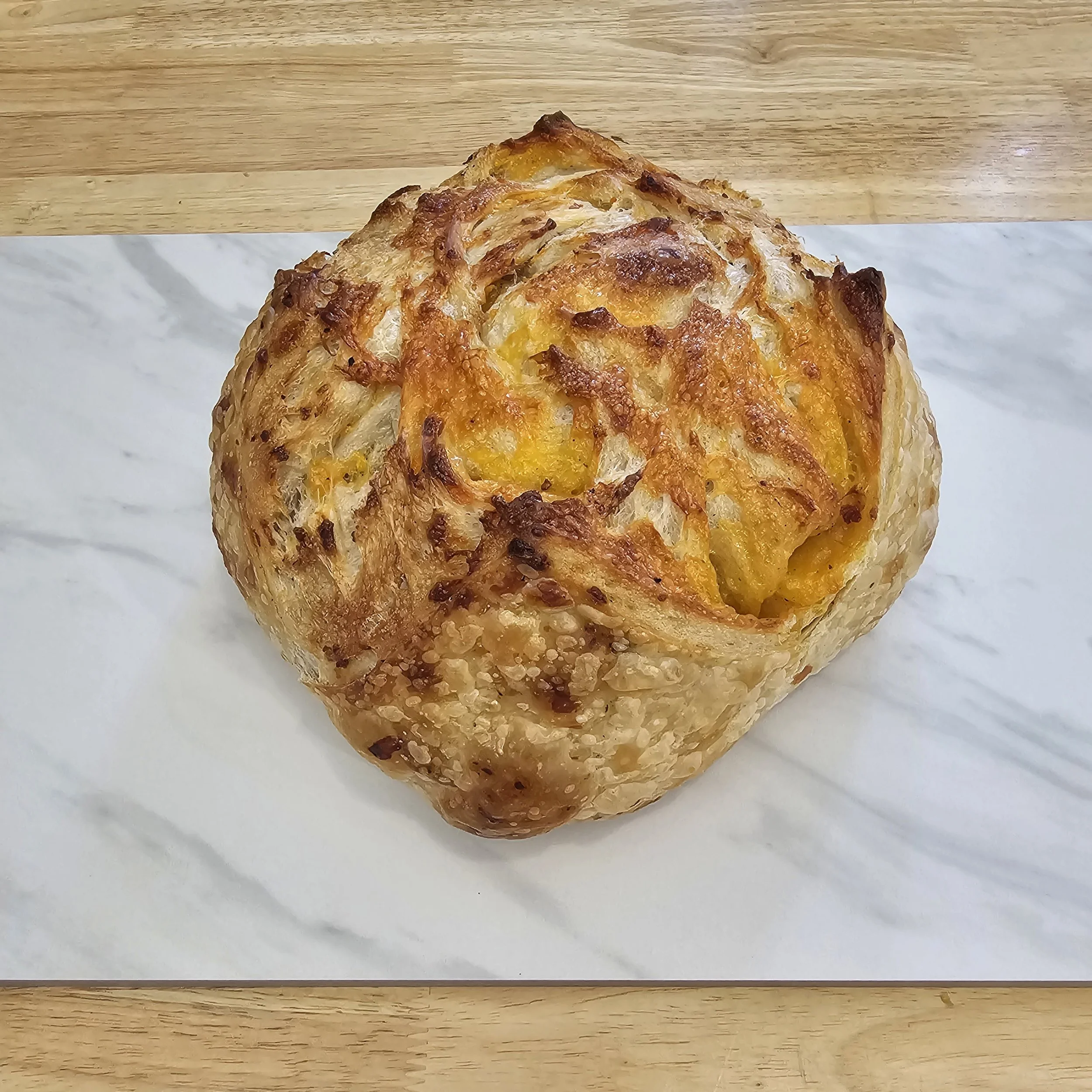 Sharp Cheddar: Sharp Cheddar Sourdough combines the tangy richness of freshly grated sharp cheddar cheese with the hearty texture of artisanal sourdough bread. 
