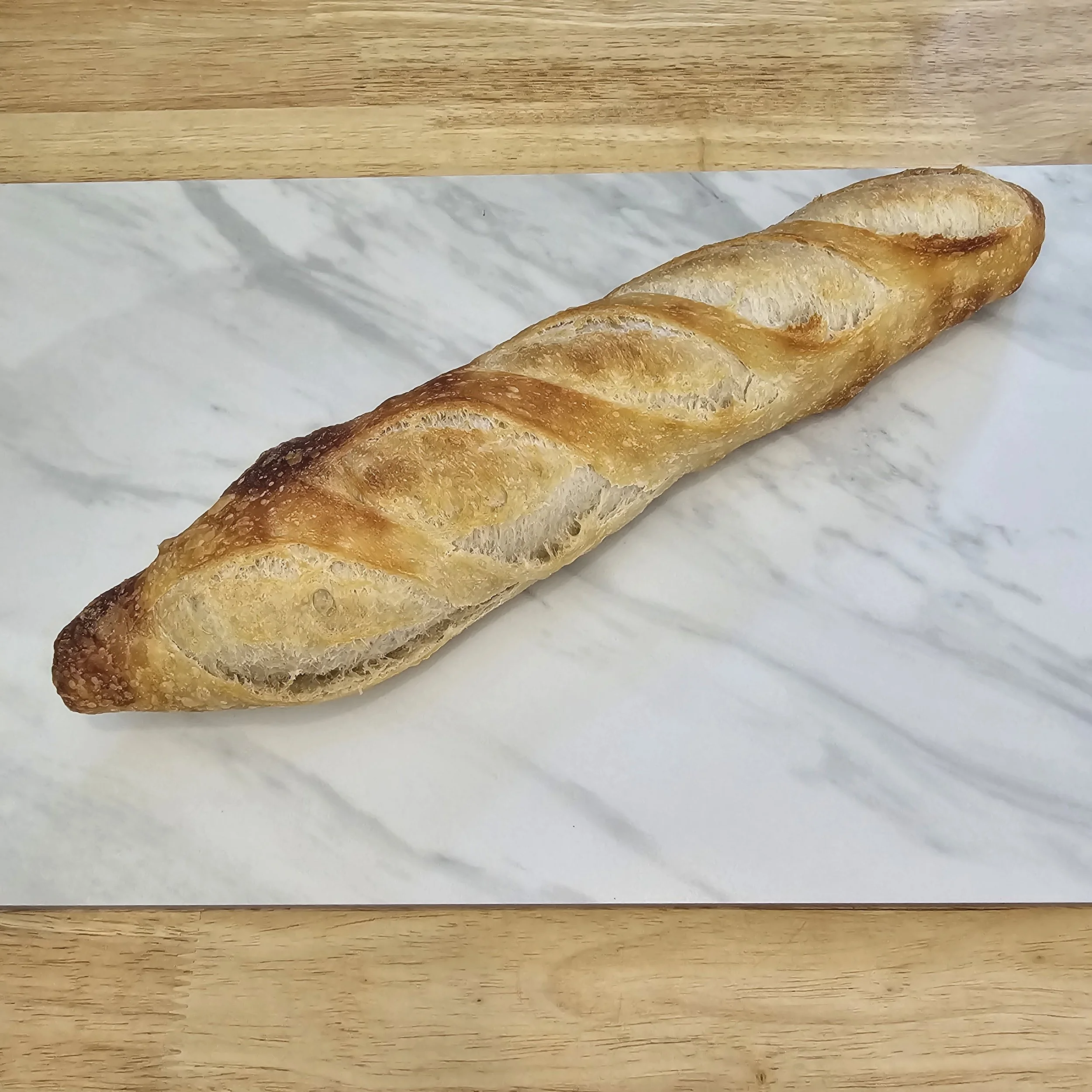 Baguette: Crafted with care, this sourdough baguette features a perfectly crispy crust and a soft, chewy interior. 