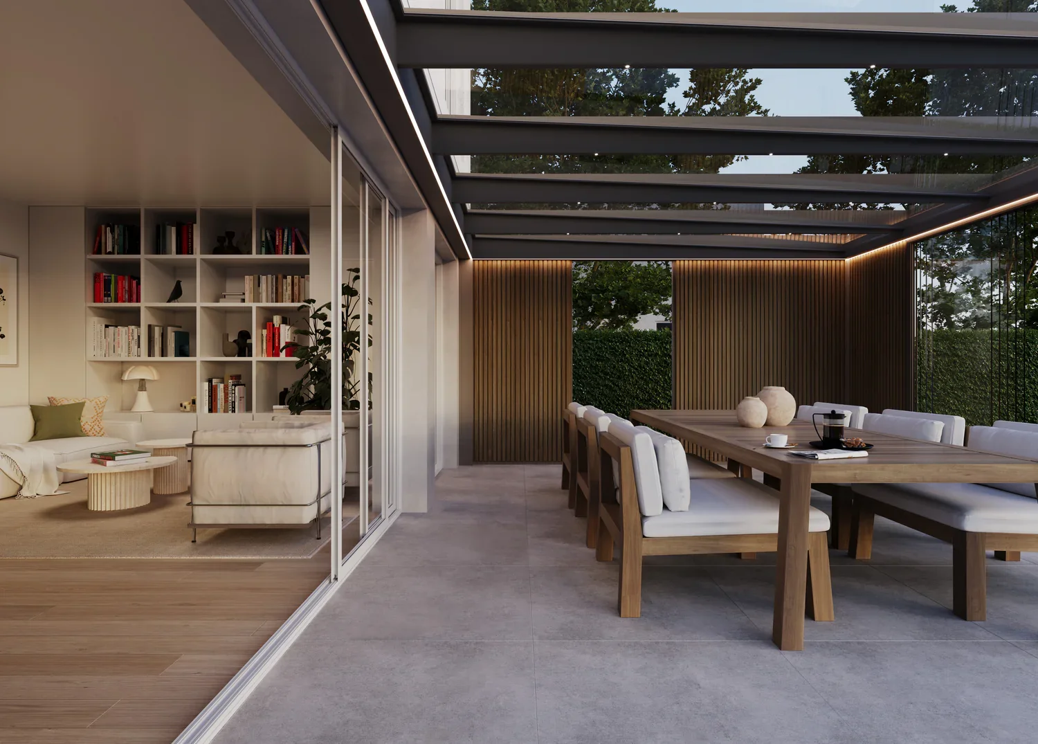 Salle à manger et espace salon dans une maison moderne avec arrière-cour verte, grande table en bois et chaises blanches, mur en bois avec étagères et livres, plafond en verre avec structure métallique.
