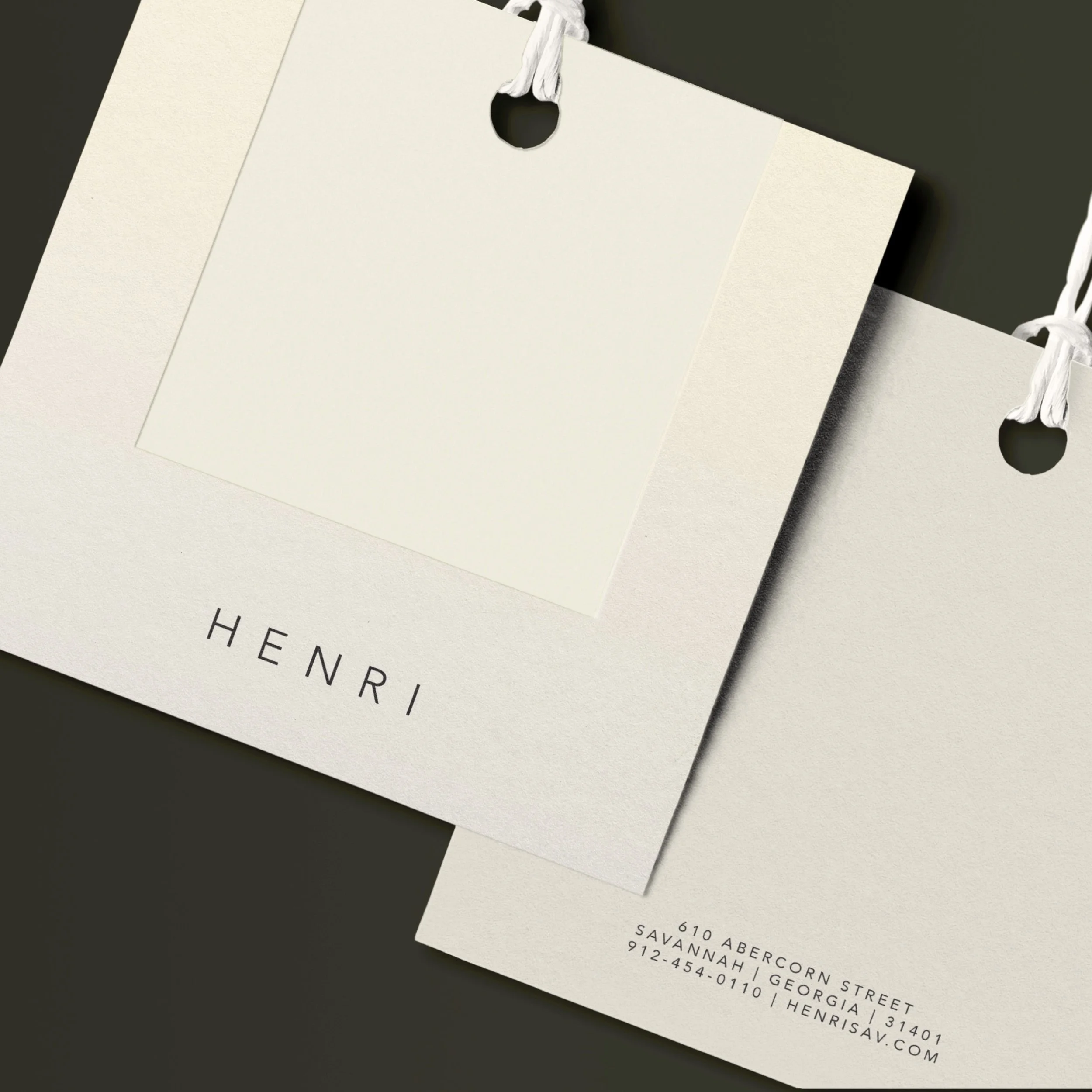 Close-up of white business envelopes with black and white string ties on black and white backgrounds, with some text visible on the envelopes.
