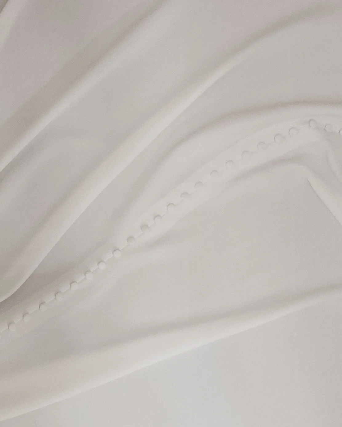 Close-up of white decorative ceiling molding with detailed patterns.