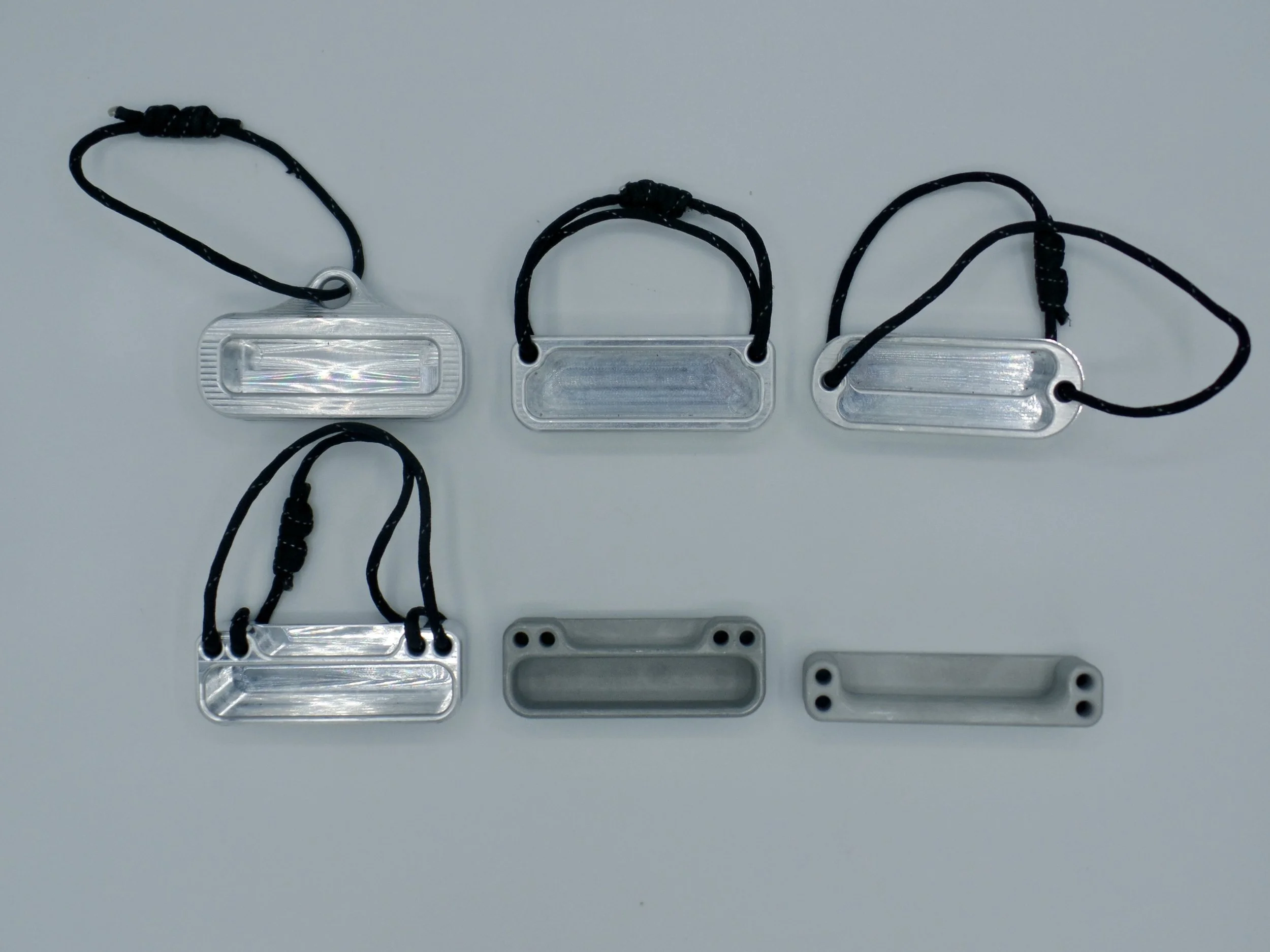 Six prototype aluminum hangboards arranged in a grid on a white background.