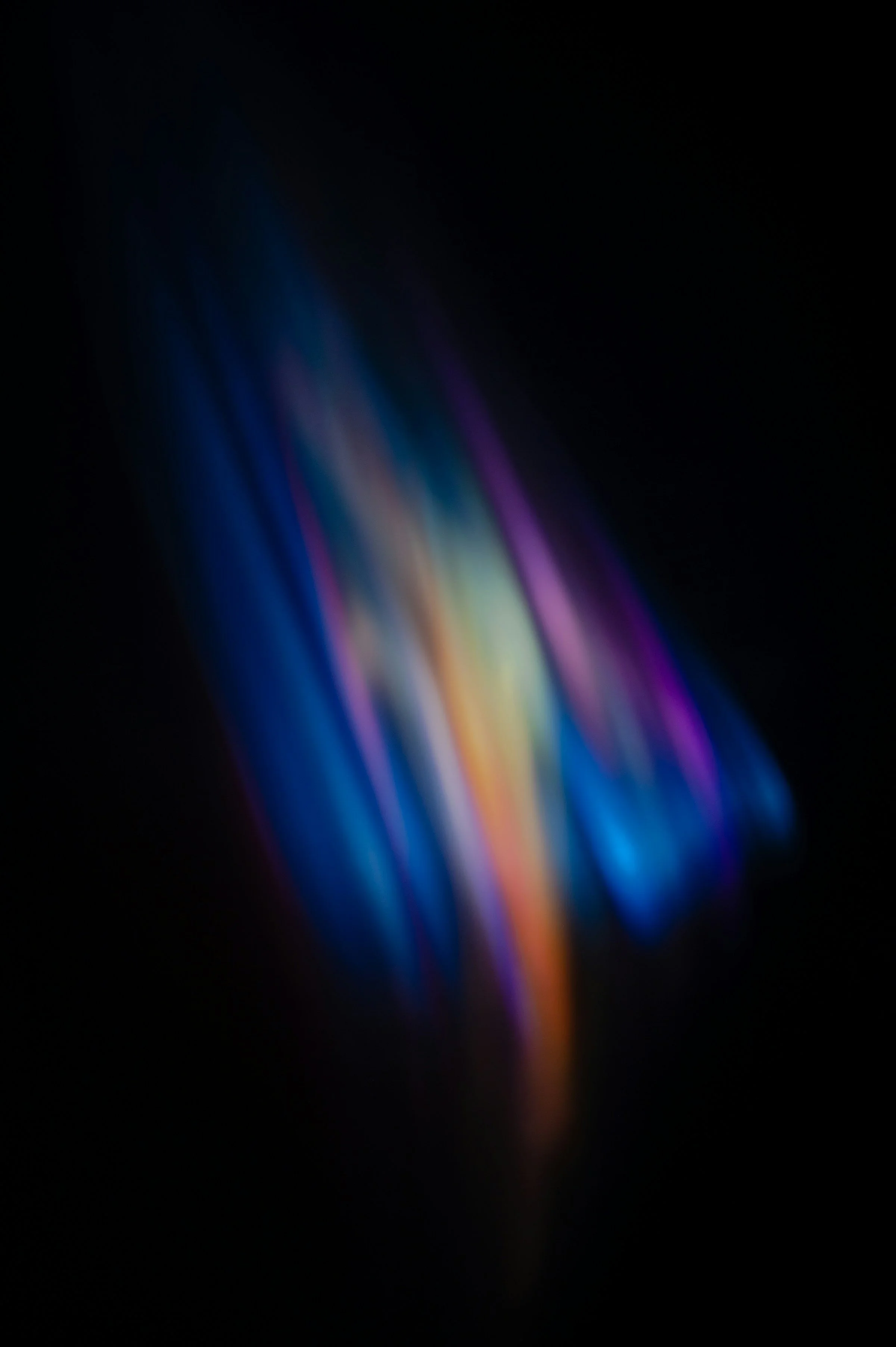 Blurred image of a smartphone screen displaying colorful streaks of light on a dark background.
