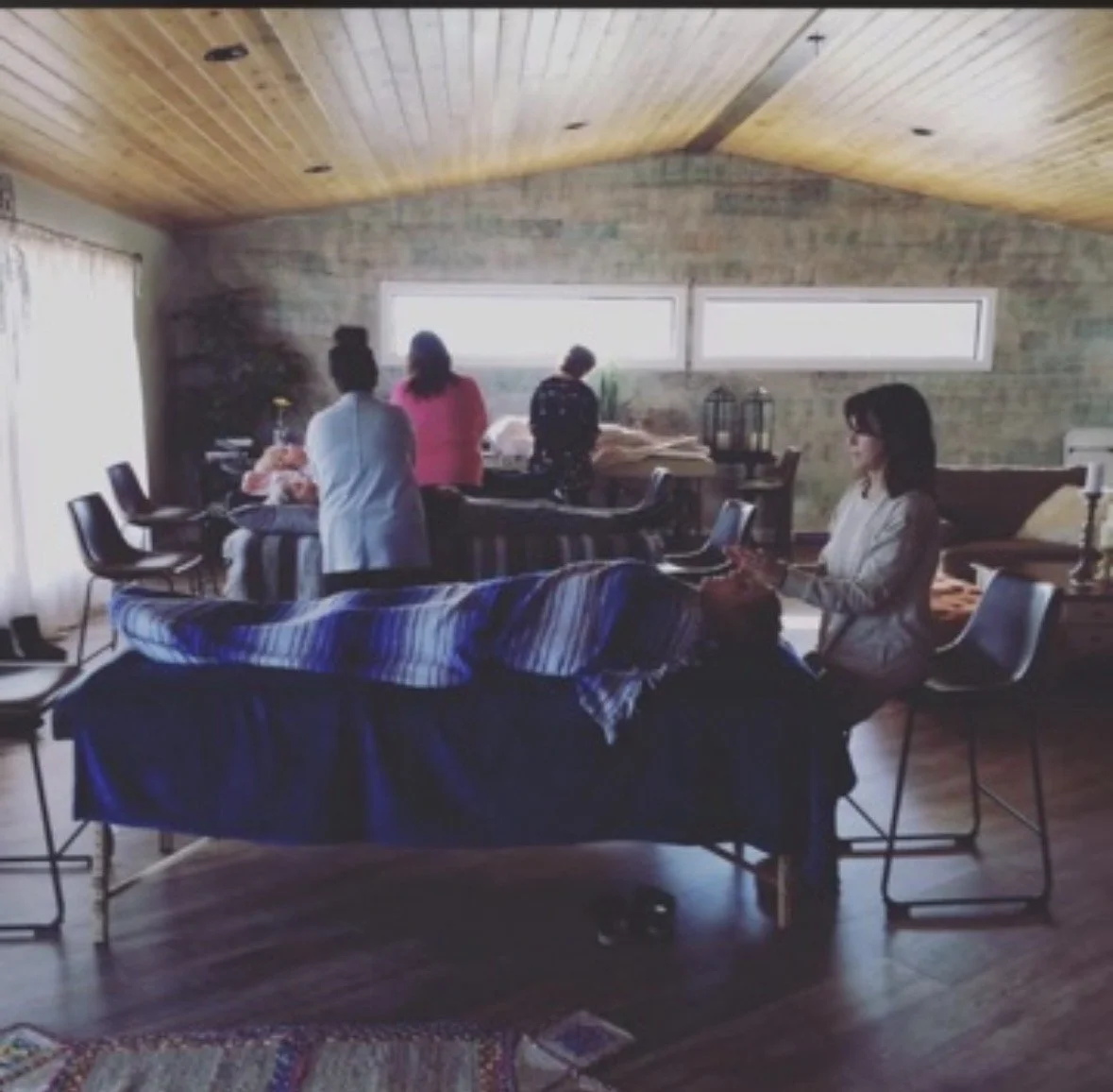 Students practicing Reiki around treatment tables in a classroom