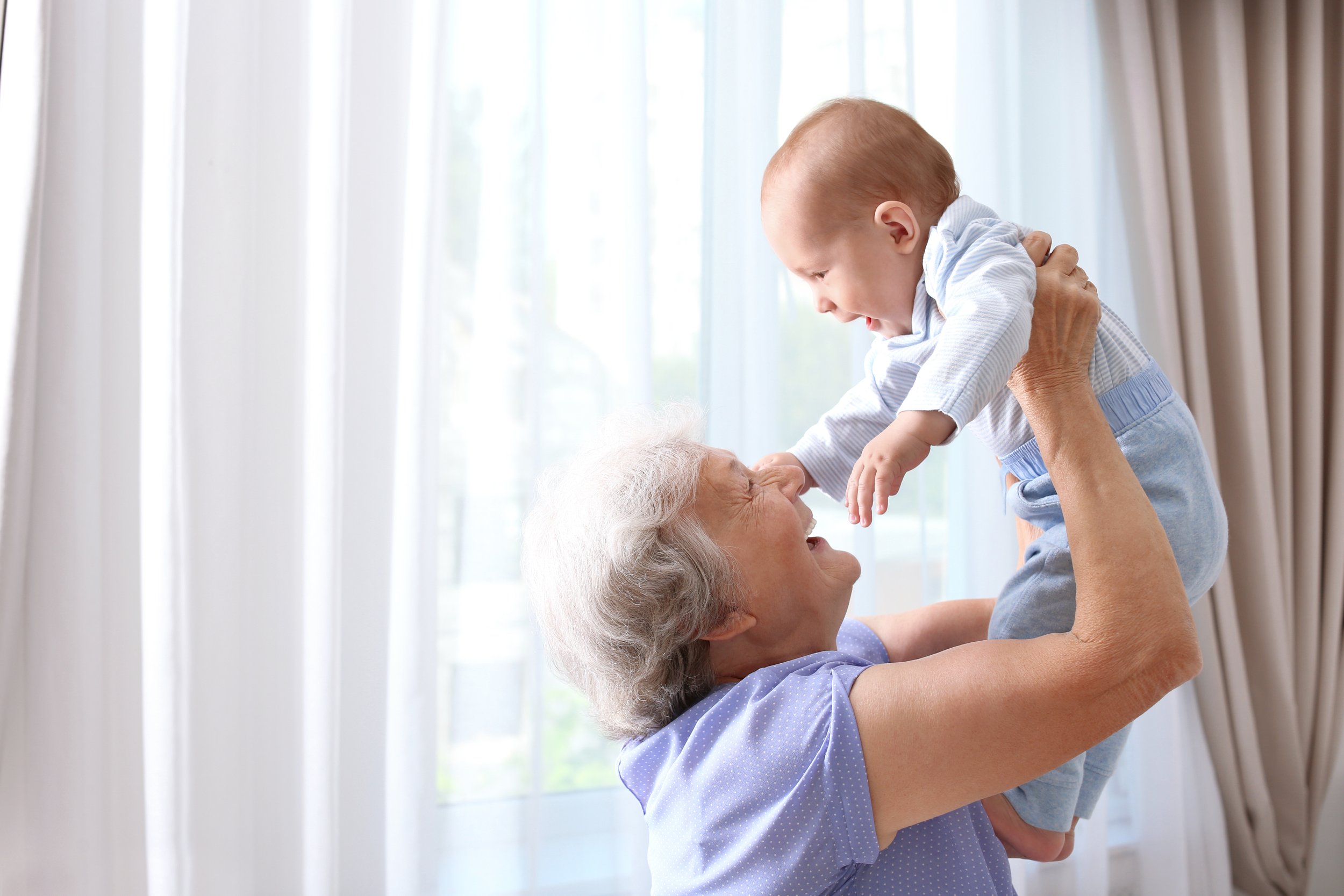Happy grandmother with baby at home