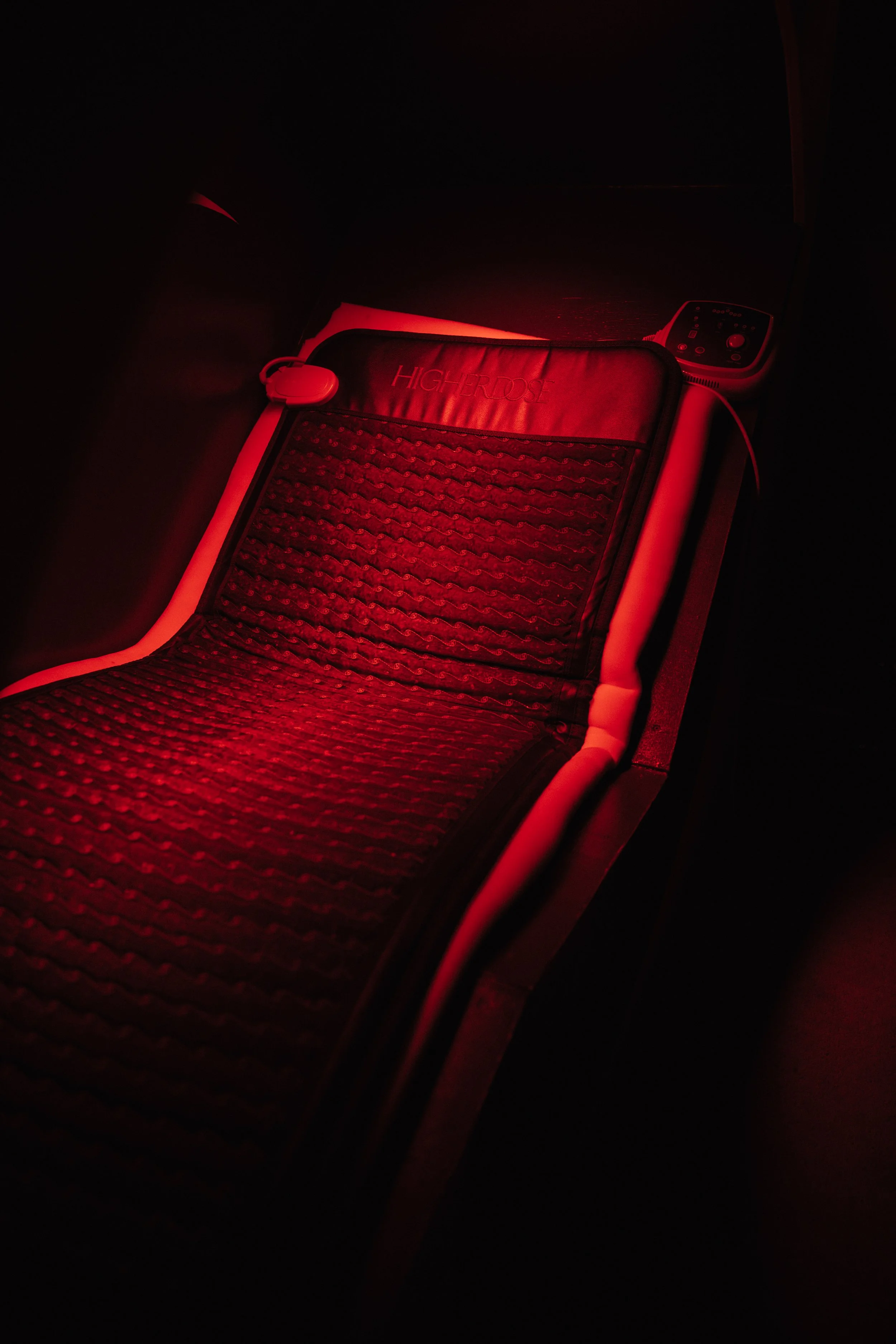 Red light therapy device on a treatment bed in a dark room