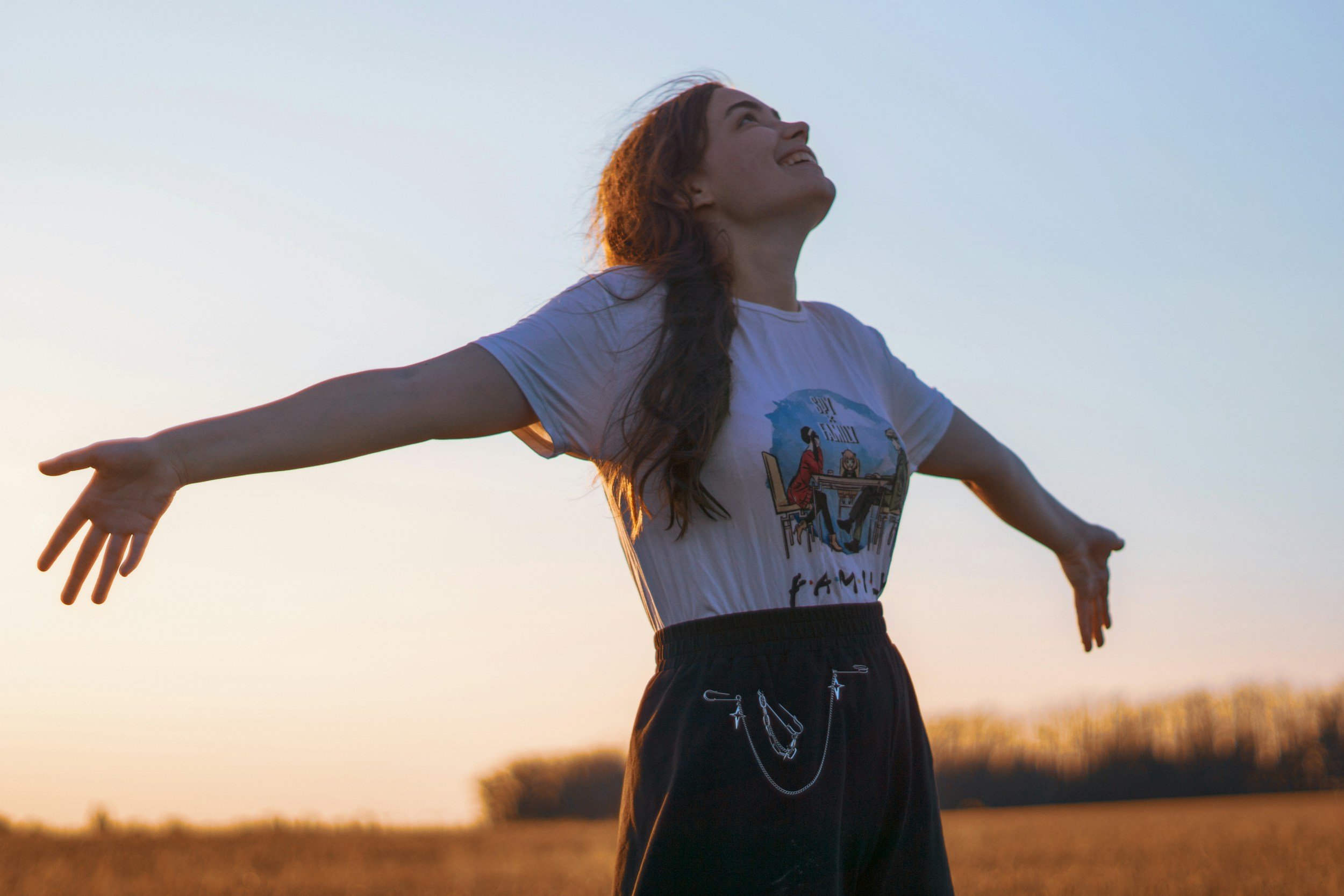 Woman embracing open space and freedom after overcoming anxiety, representing nervous system regulation, emotional wellbeing, anxiety recovery, self-confidence, and somatic coaching support.