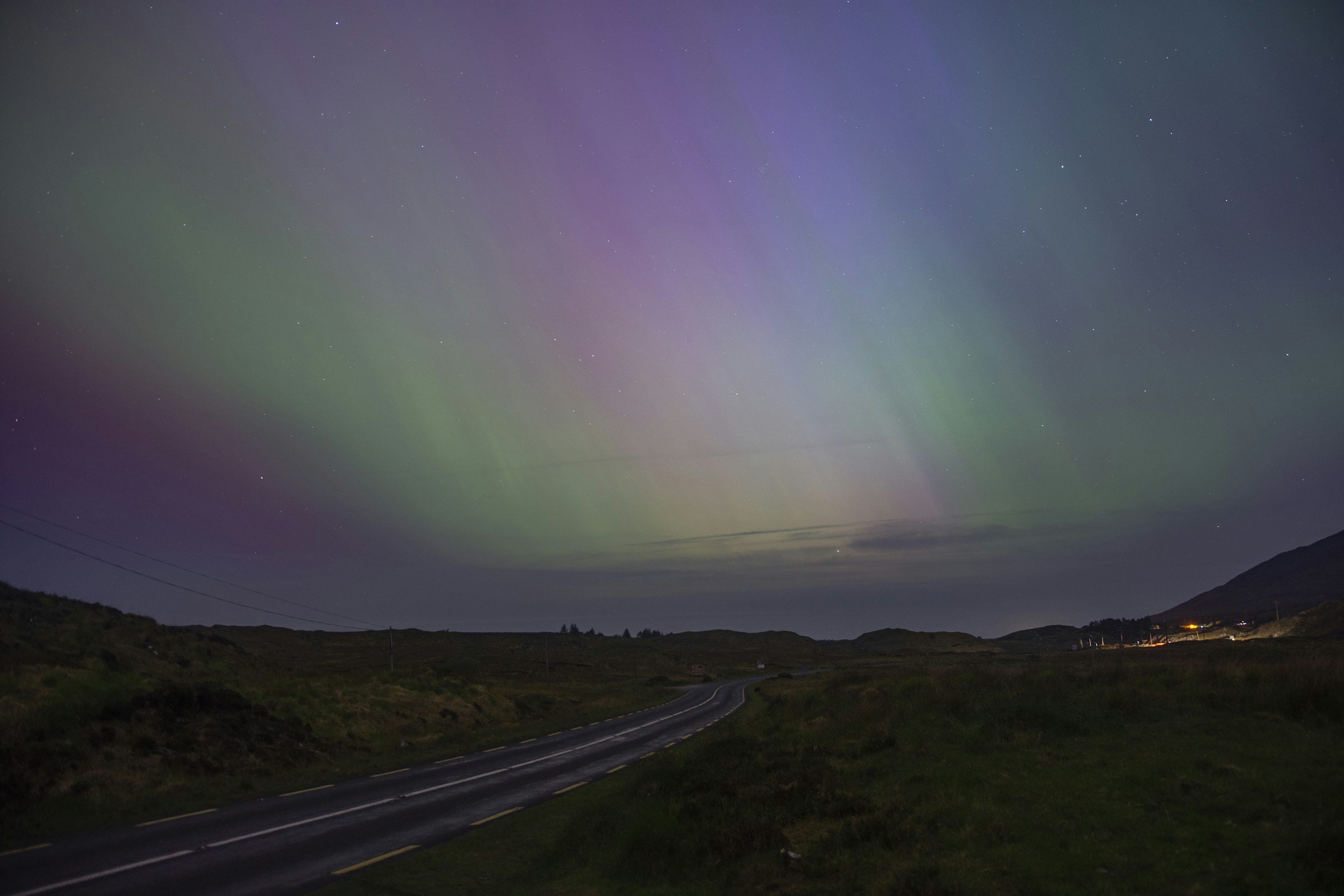 Northern lights illuminating the night sky above an open landscape, symbolizing possibility, personal growth, self-discovery, expanded perspective, and transformation through somatic coaching.