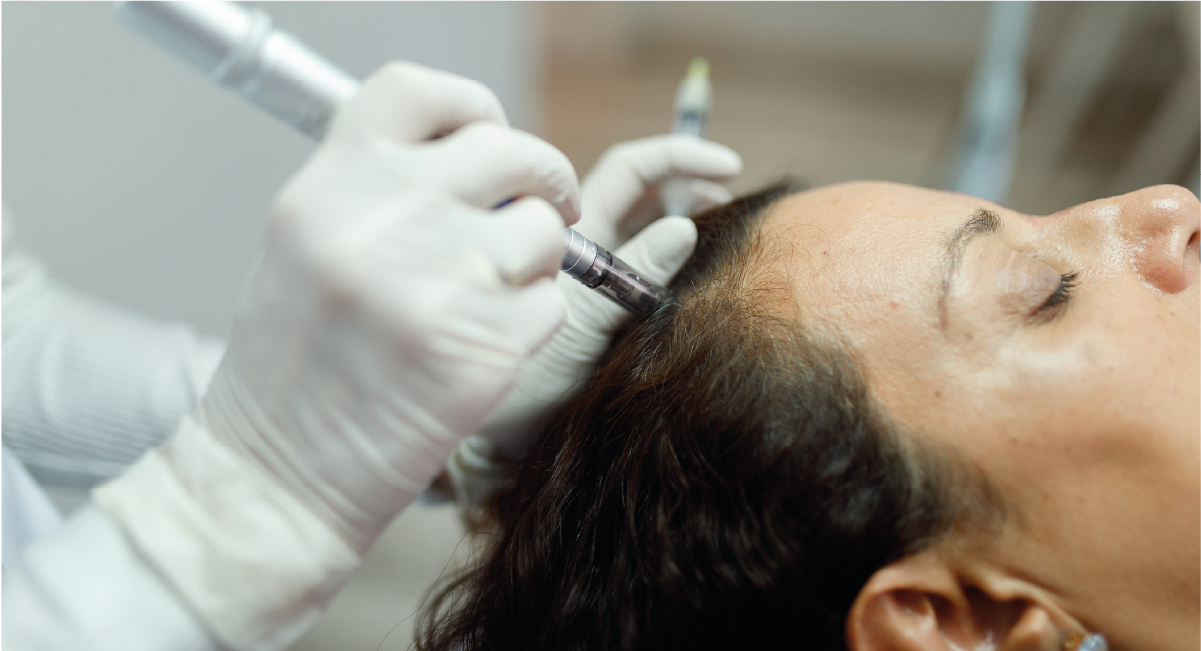 A landscape with a mountain range featuring snow-capped peaks in the background, and a small modern building on a grassy hillside in the foreground.