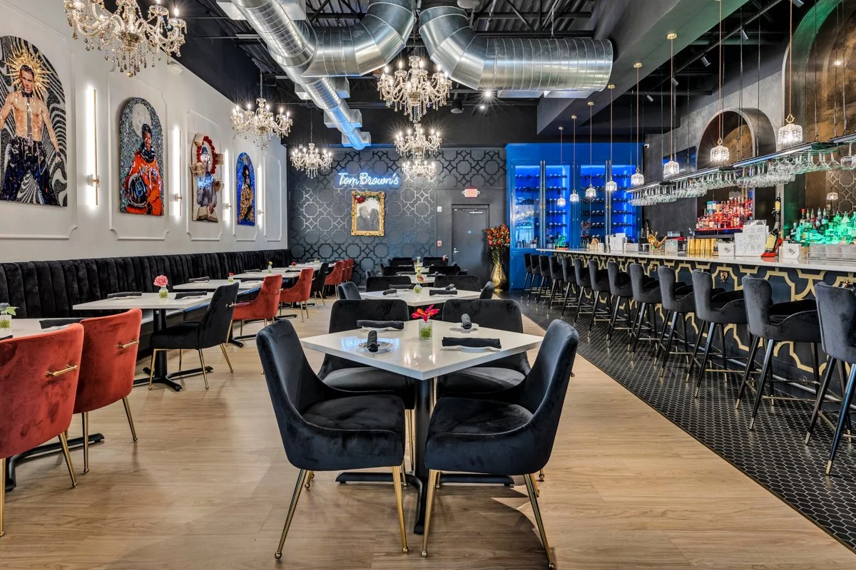 Dining area with pop artwork near the bar area. Red and black velvet chairs