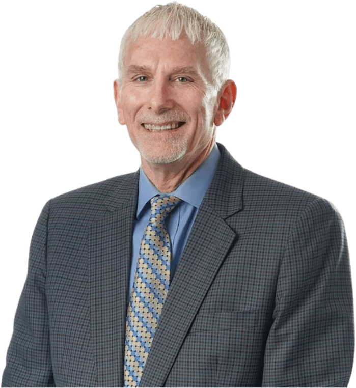 Dr. Haggquist smiling, dressed in a checkered blazer, blue shirt, and a patterned tie.