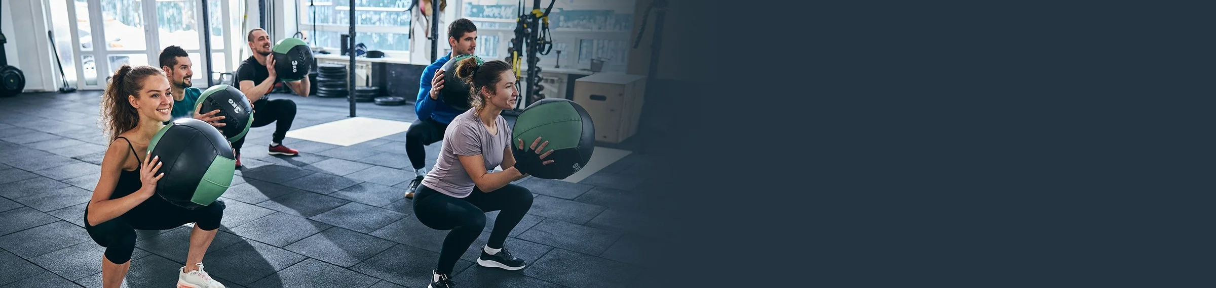 Group of people exercising with medicine balls in a gym