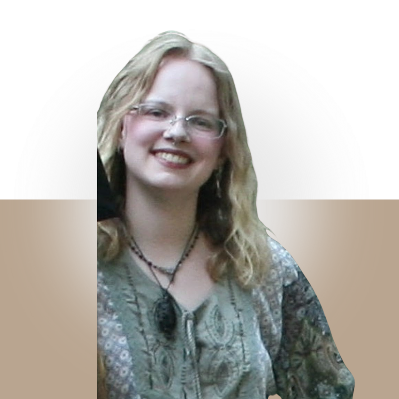Photograph of a woman with glasses, blonde wavy hair, smiling, wearing a patterned blouse, necklace, and earrings.