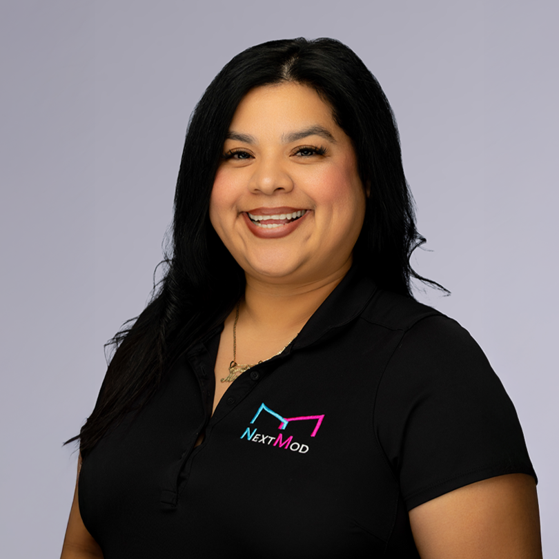 A woman with long black hair smiling, wearing a black polo shirt with a colorful logo reading "NextMod".