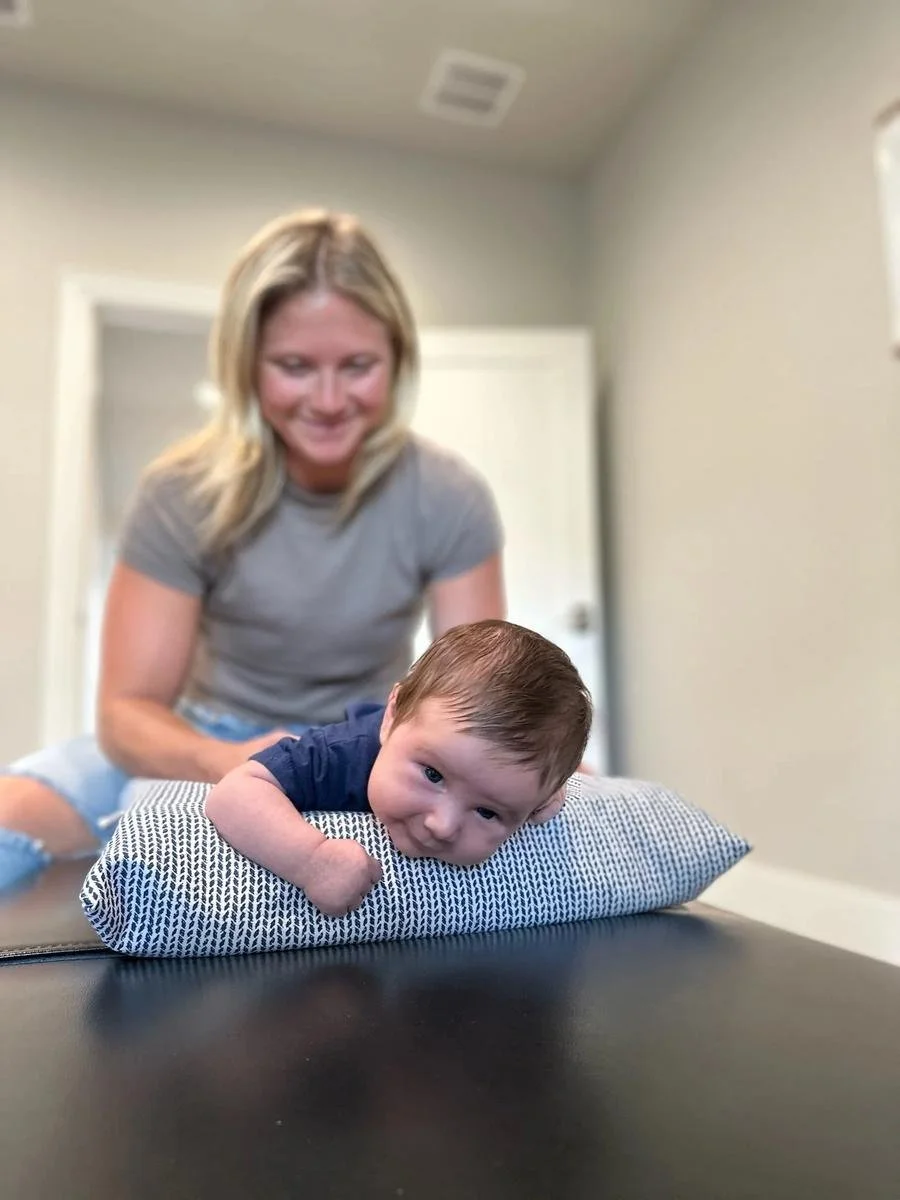 Toddler tummy-time positioning support for torticollis at Social House Chiropractic in Prosper, TX.