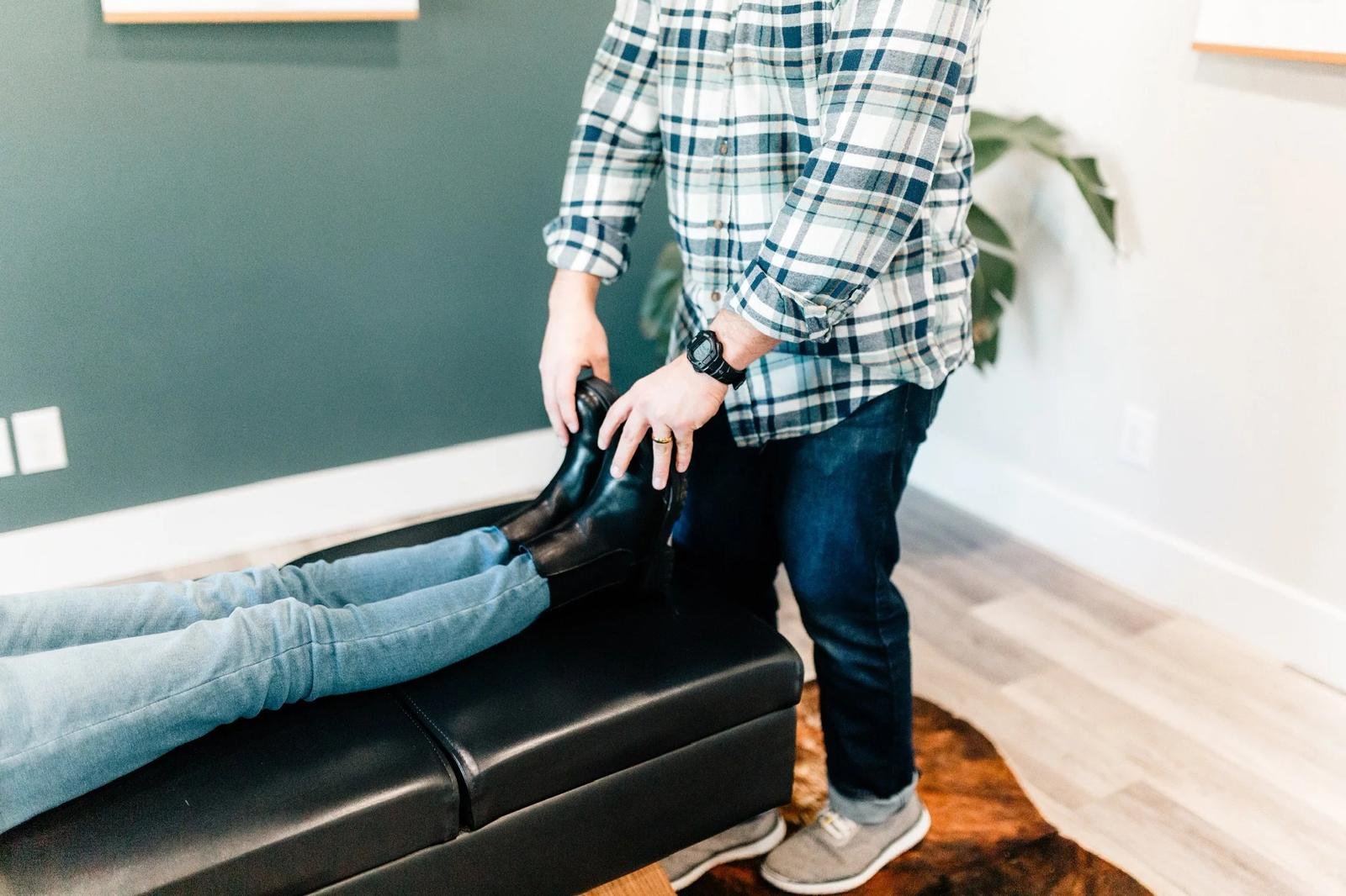 Dr. Collin Walding performing a lower extremity adjustment for an adult patient at Social House Chiropractic, a family chiropractor in Prosper, TX.