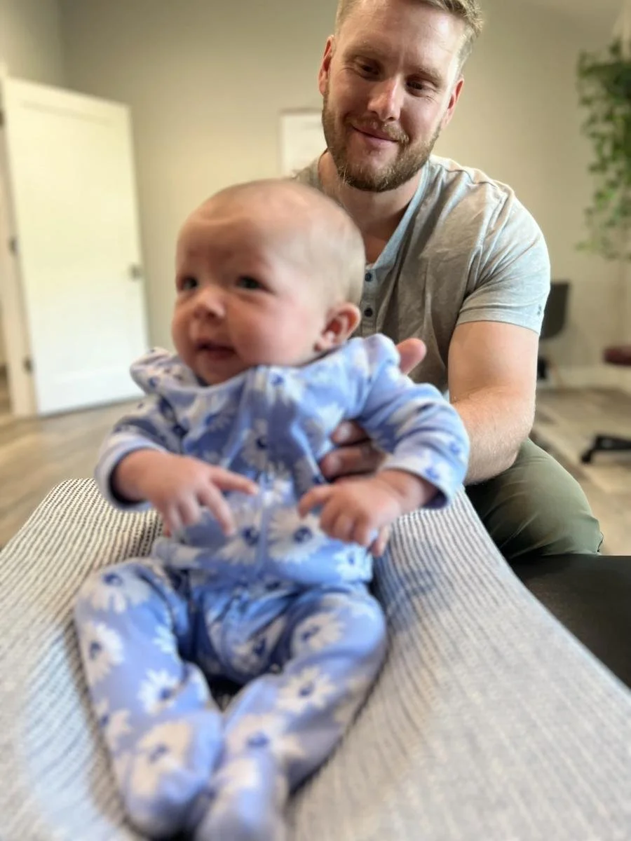 Dad and baby at Social House Chiropractic in Prosper, TX. Pre- and post-frenectomy chiropractic and craniosacral support for tongue tie.