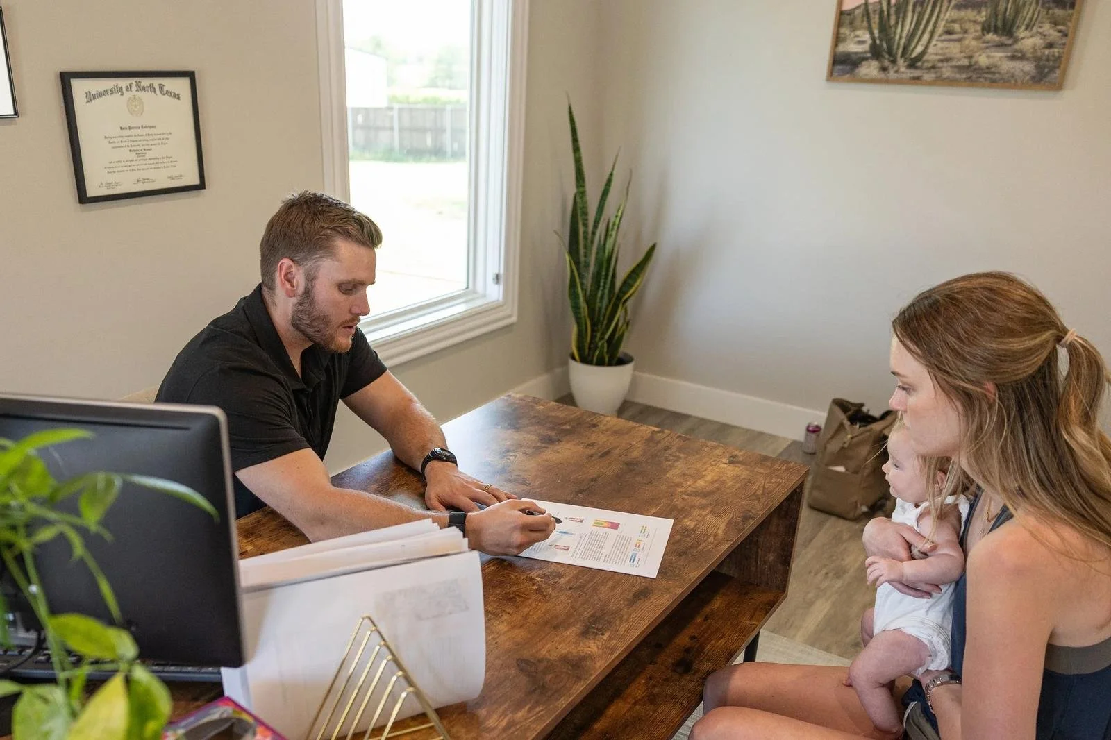 Dr. Collin Walding reviewing scan results with a prenatal patient at Social House Chiropractic in Prosper, TX. Webster Certified prenatal care.