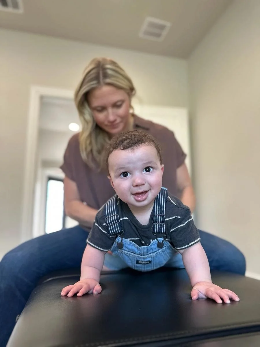Smiling baby patient at Social House Chiropractic in Prosper, TX. Pediatric chiropractic support for plagiocephaly and head shape concerns.
