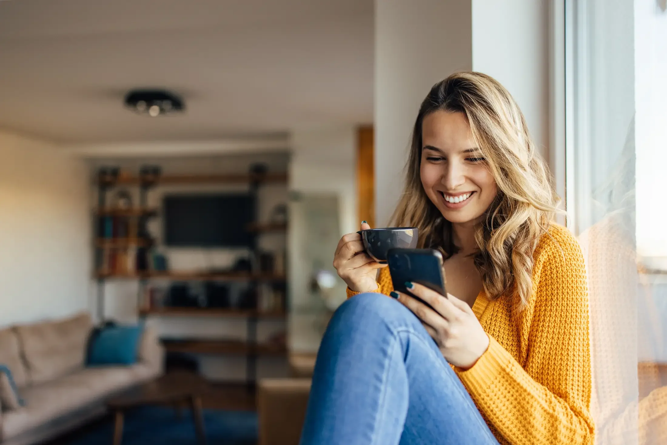 Woman drinking her coffee while reading something on her mobile device