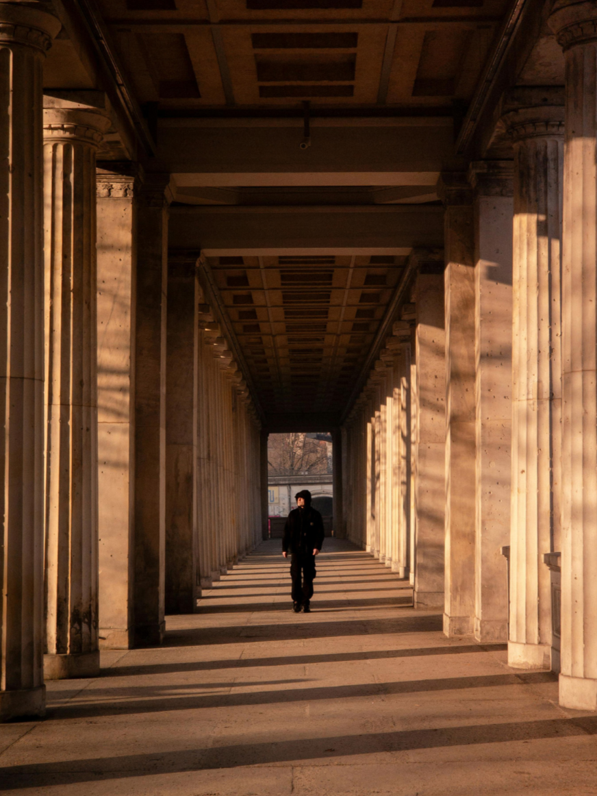 Individual walking through hallway, representing stress, isolation, and support for high-pressure roles