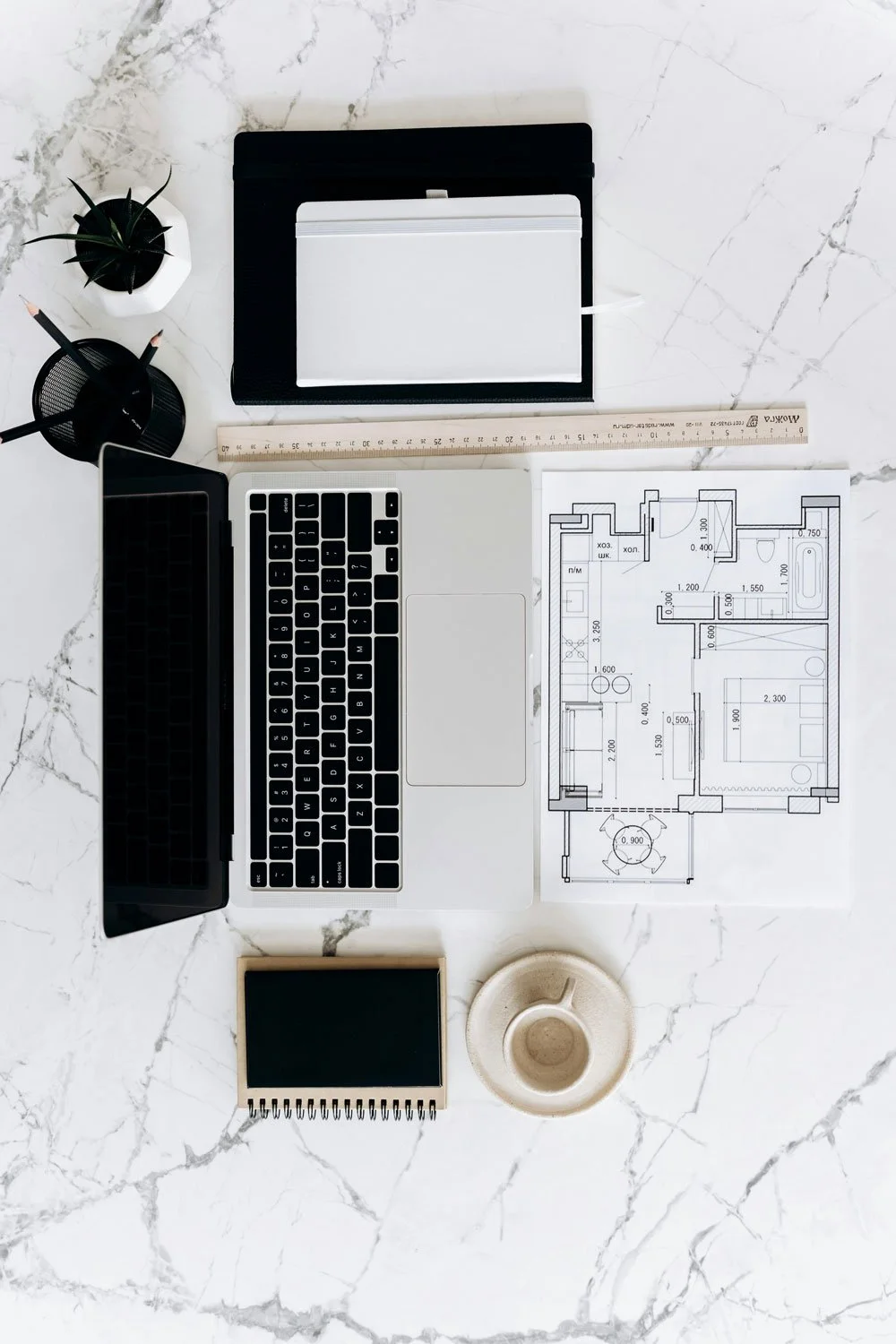 Plan d'architecture, ordinateur portable, cahier, règle, croquis, plantes, tasse à café, bloc-notes, boîte à crayons, cahier