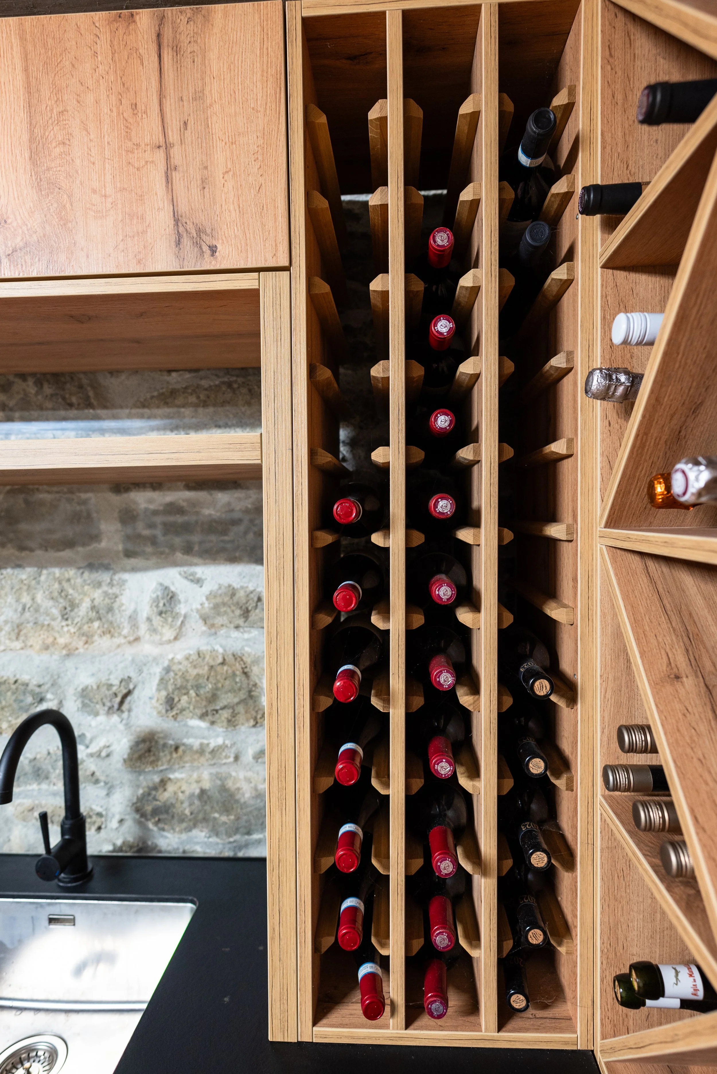 Rangement à bouteilles de vin en bois avec plusieurs bouteilles rangées verticalement.