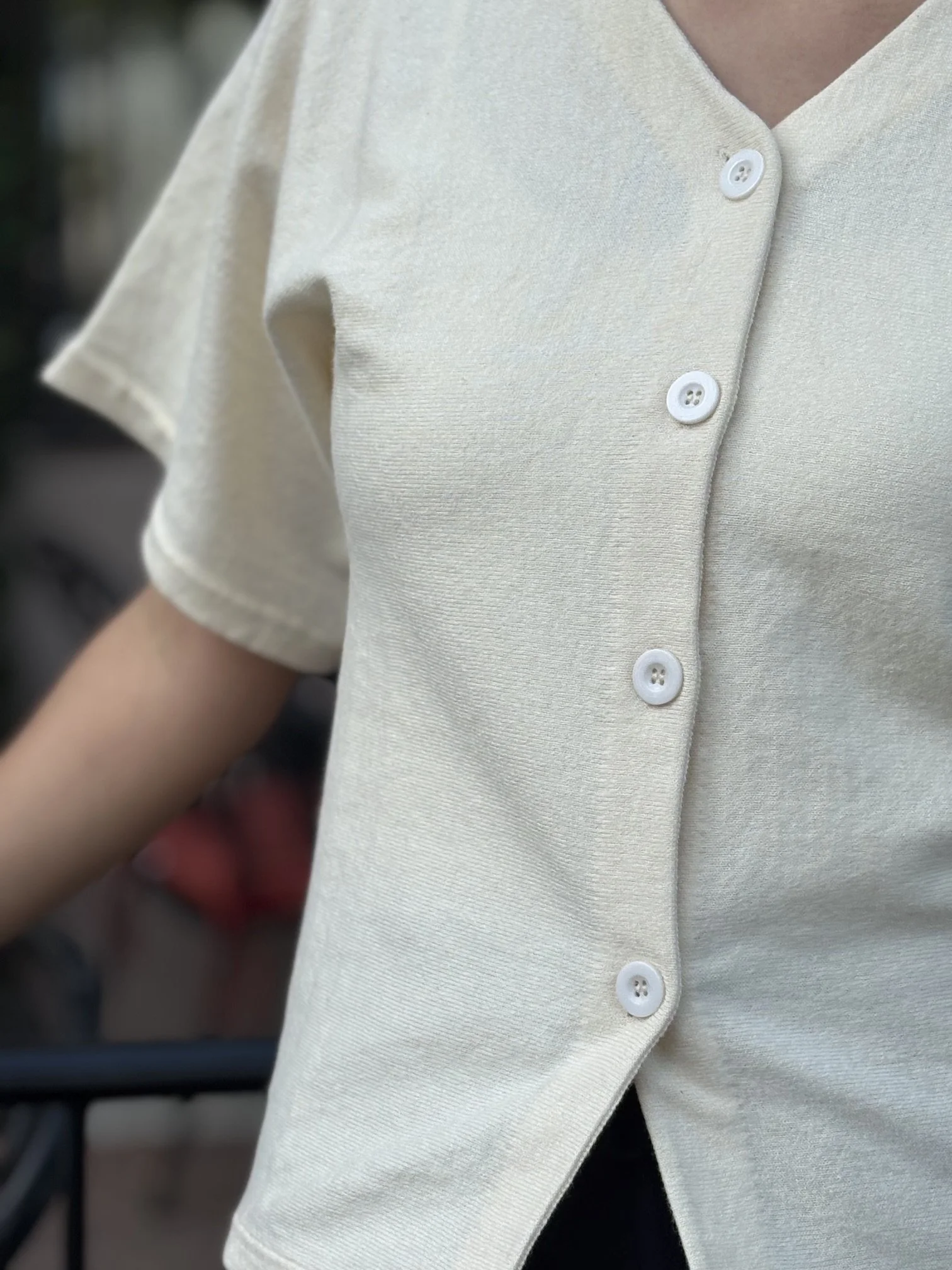 Women’s ivory V-neck blouse with a relaxed fit and soft, flowy silhouette