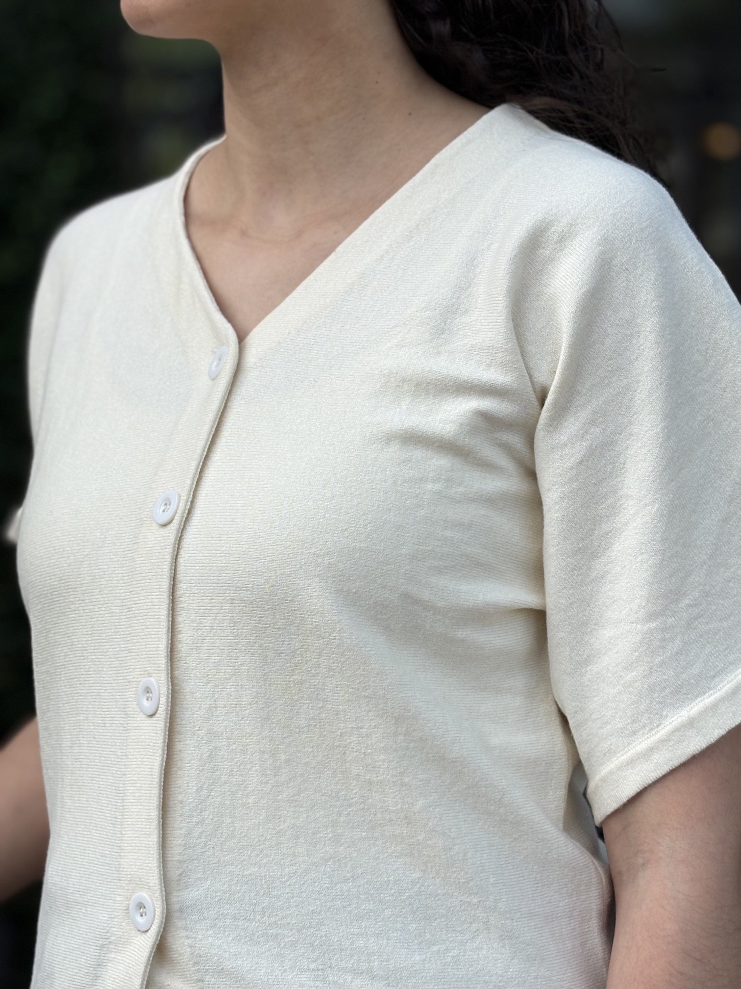 Women’s ivory V-neck blouse with a relaxed fit and soft, flowy silhouette