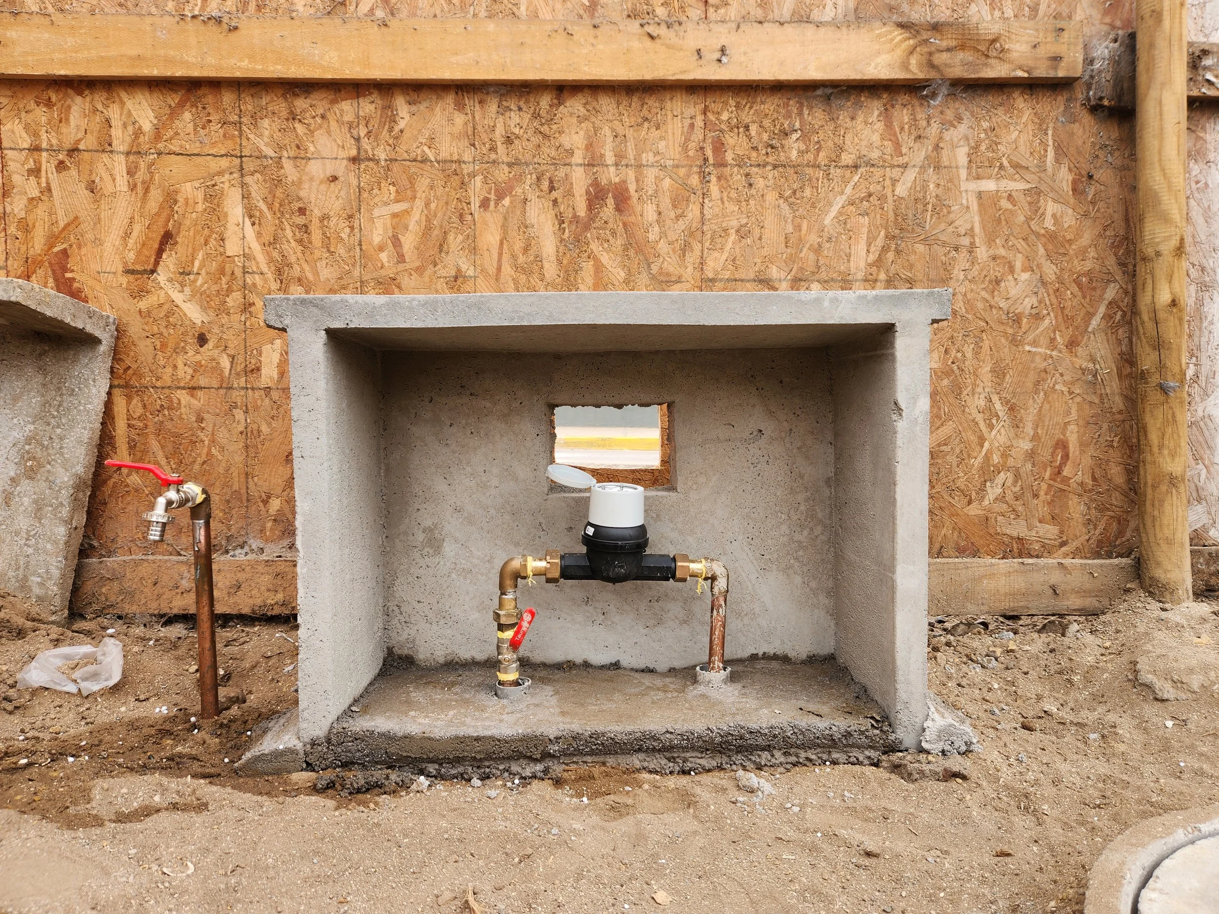 Construcción de una estructura de pared con bloques de concreto y madera en un sitio de construcción.