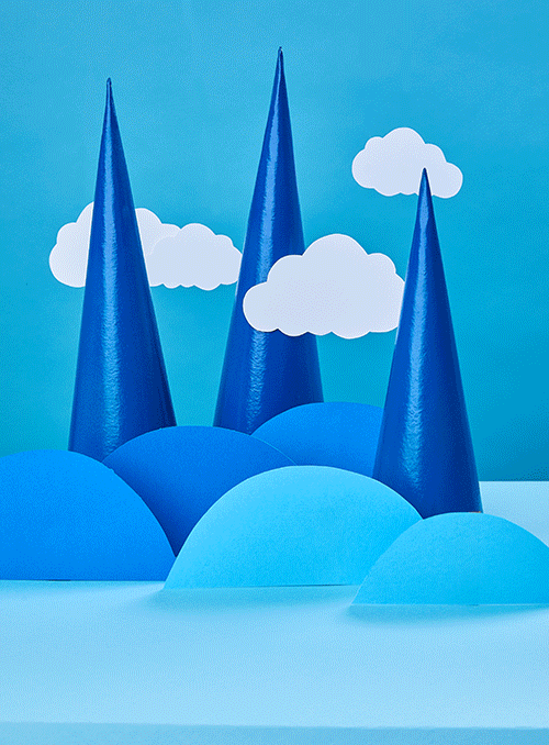 Blue paper craft landscape with blue conical trees and white clouds