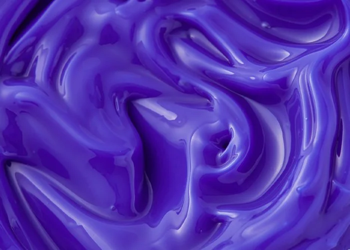 Close-up image of swirling purple and violet liquid or paint.